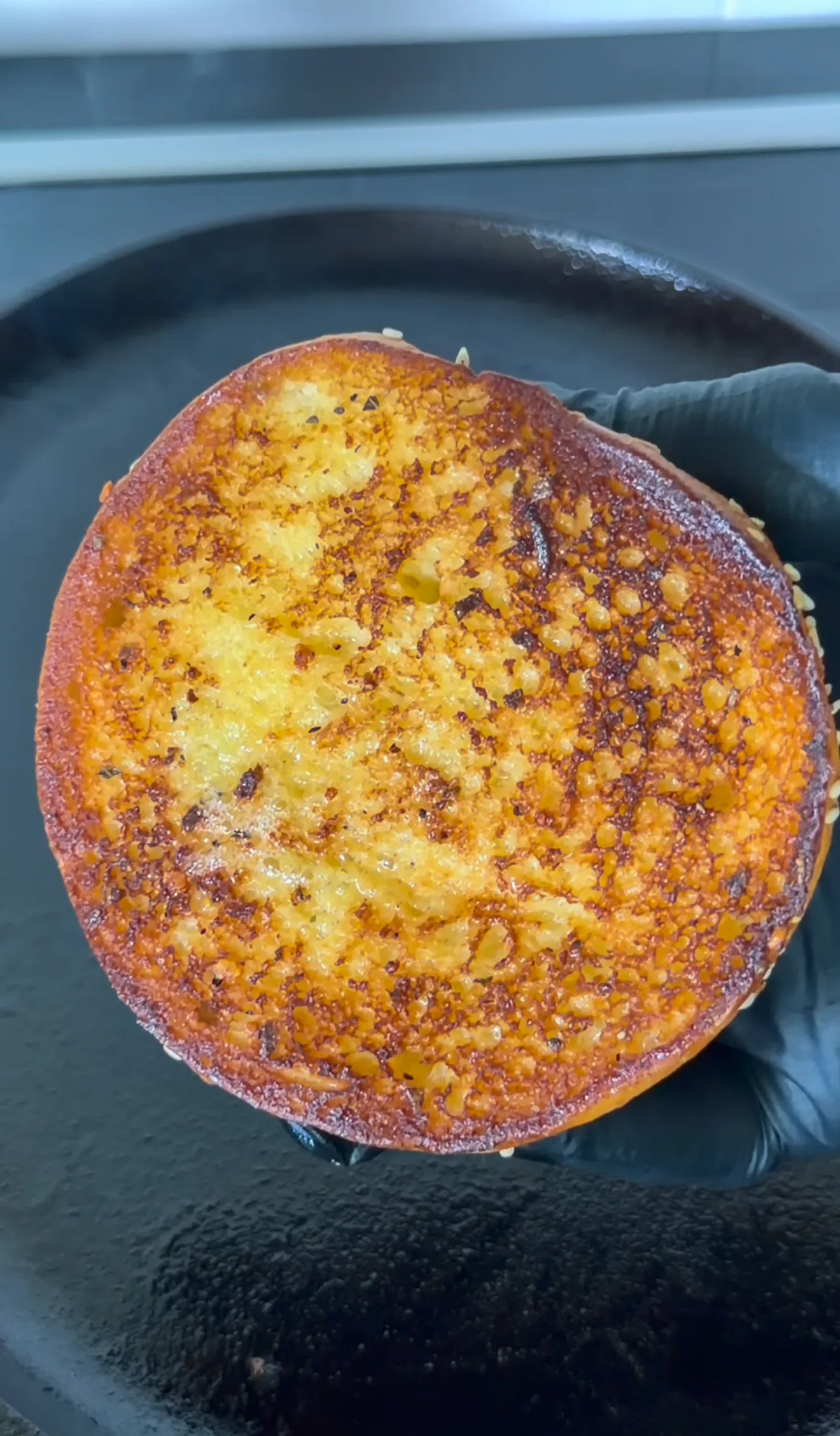 Golden brown bacon jam smash burger patty with caramelized edges in cast iron skillet