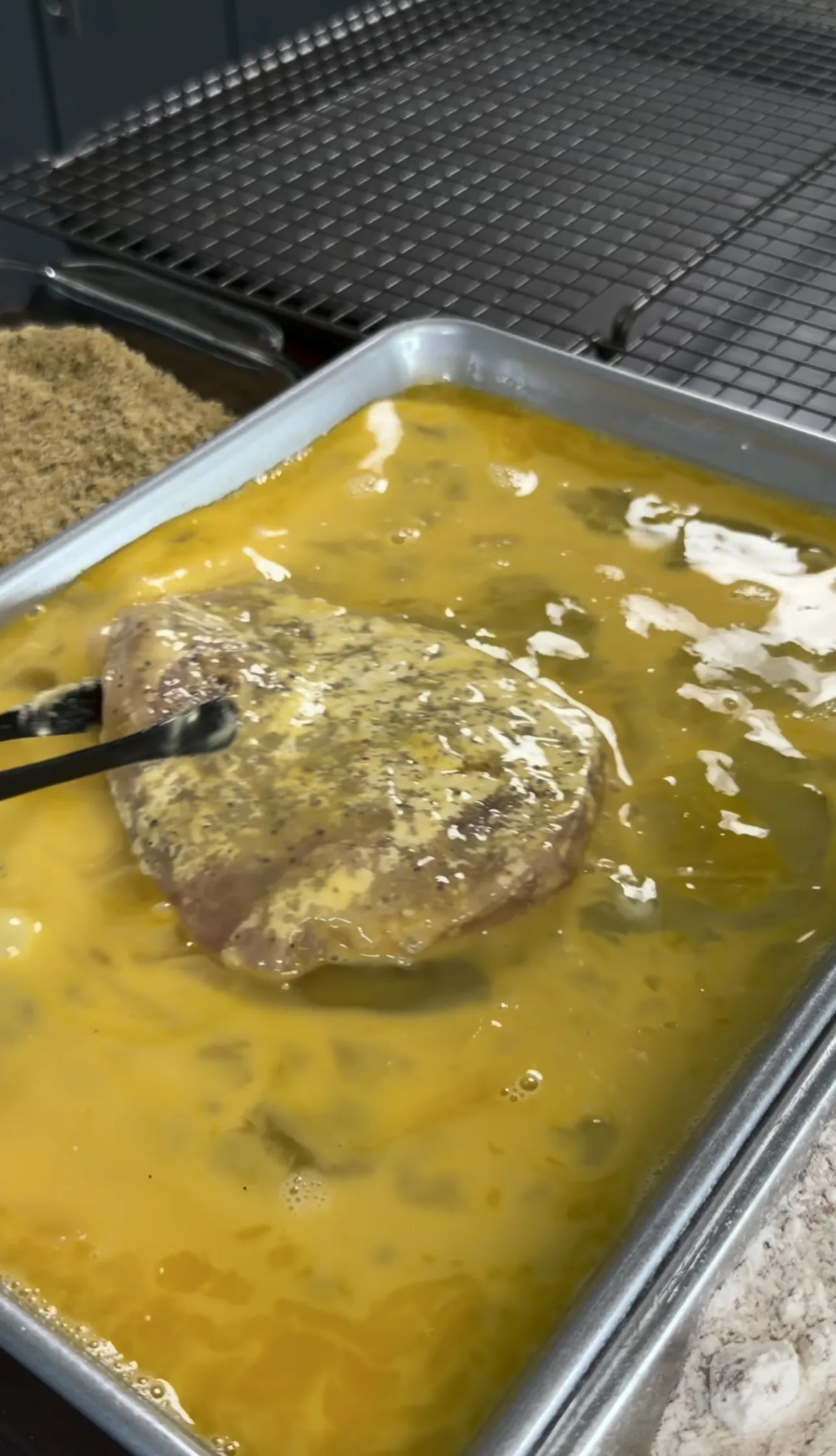Chicken cutlet frying golden in oil in a pan