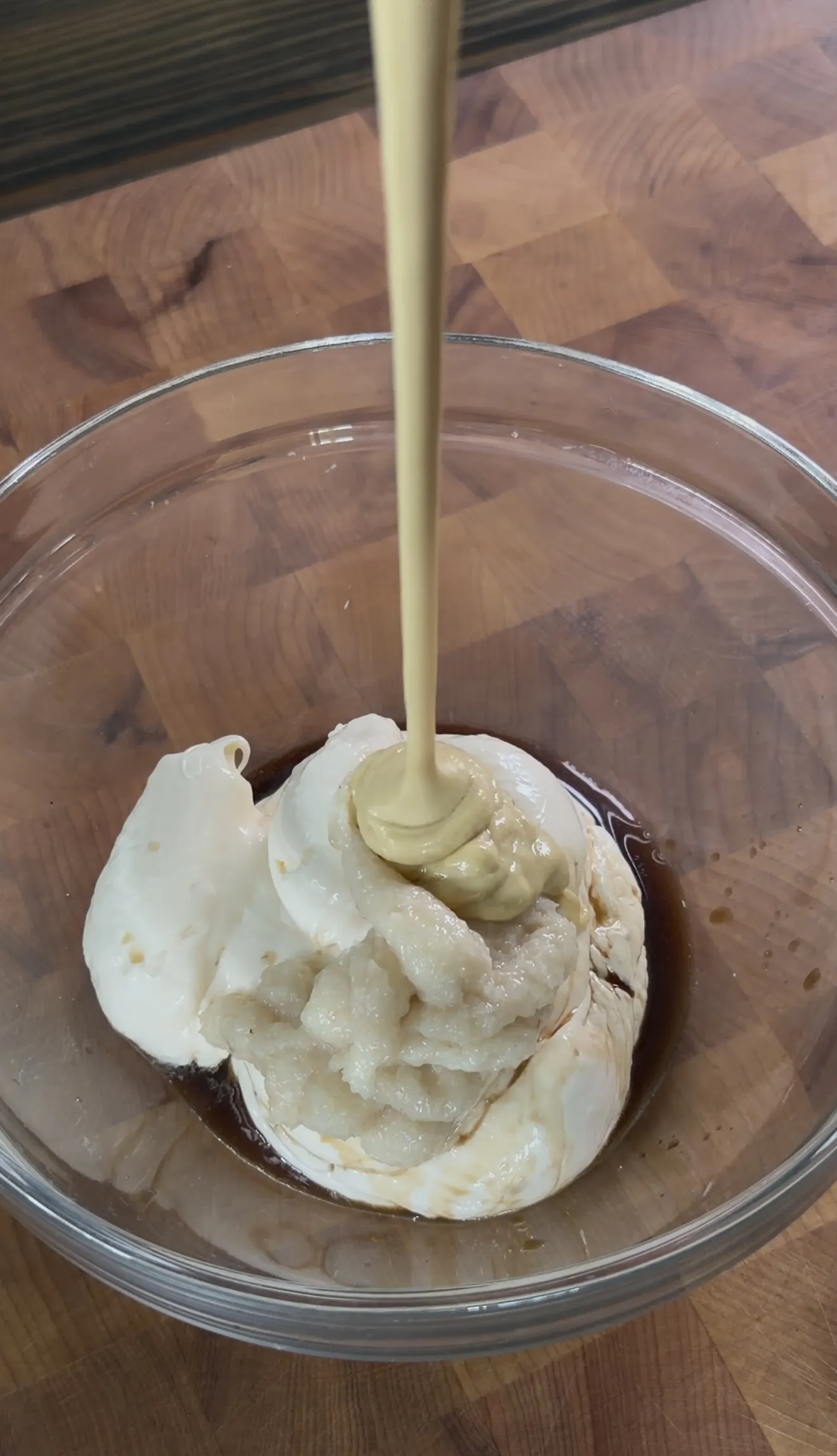 Creamy homemade Caesar dressing being whisked in a mixing bowl