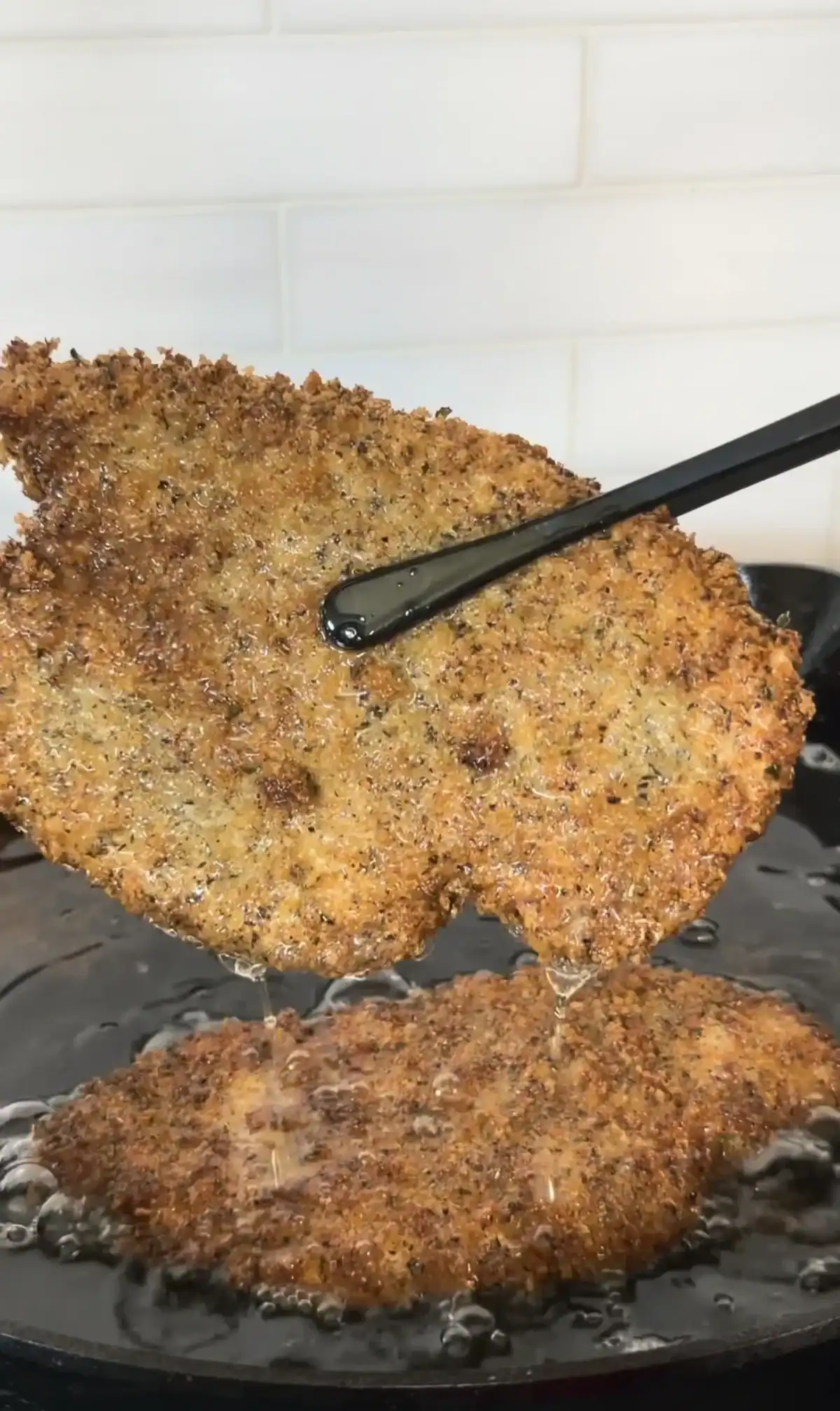 Crispy breaded chicken cutlets frying in a pan at 350 degrees
