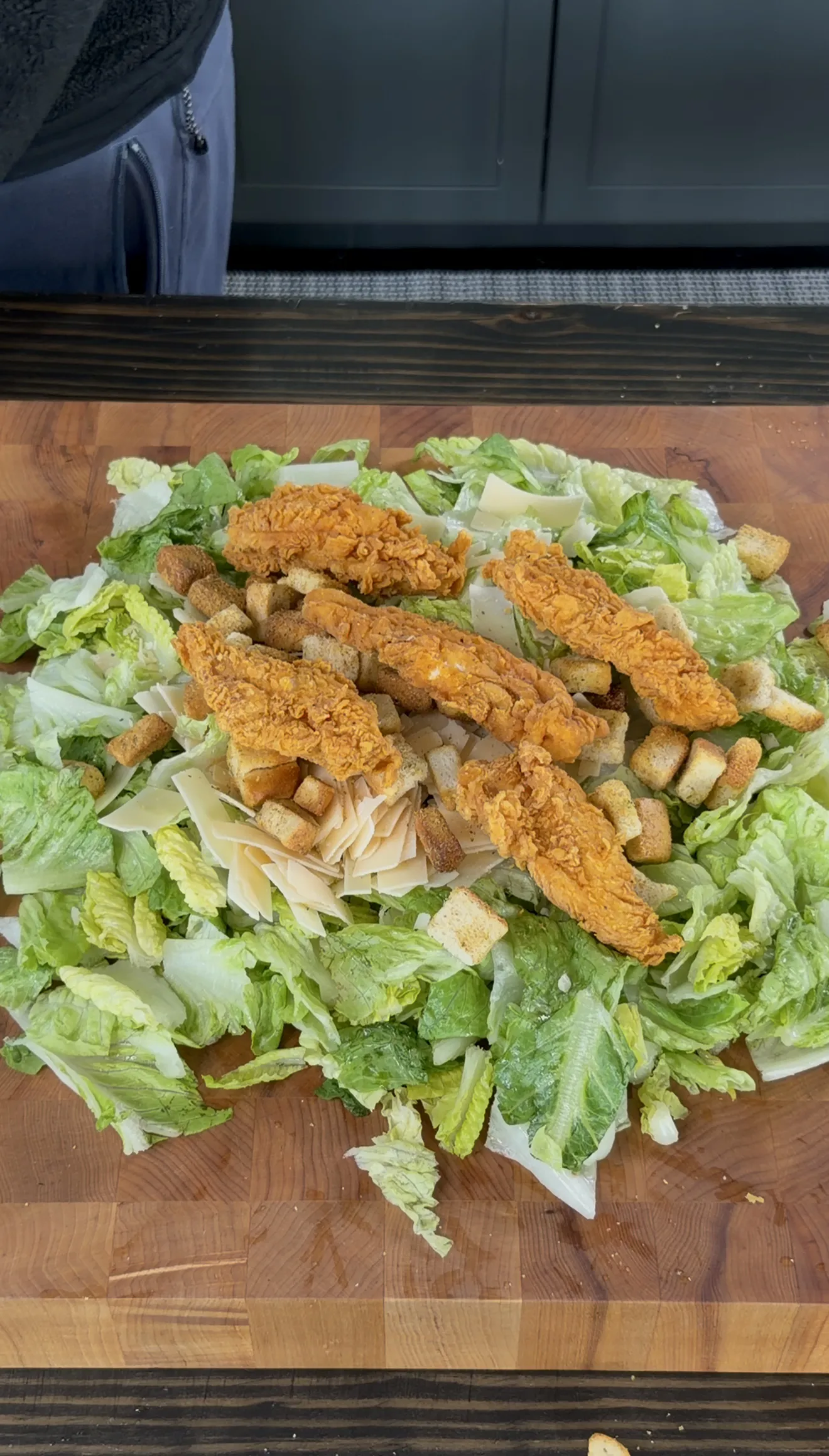 Crispy fried chicken tenders chopped for chicken caesar sliders on a cutting board