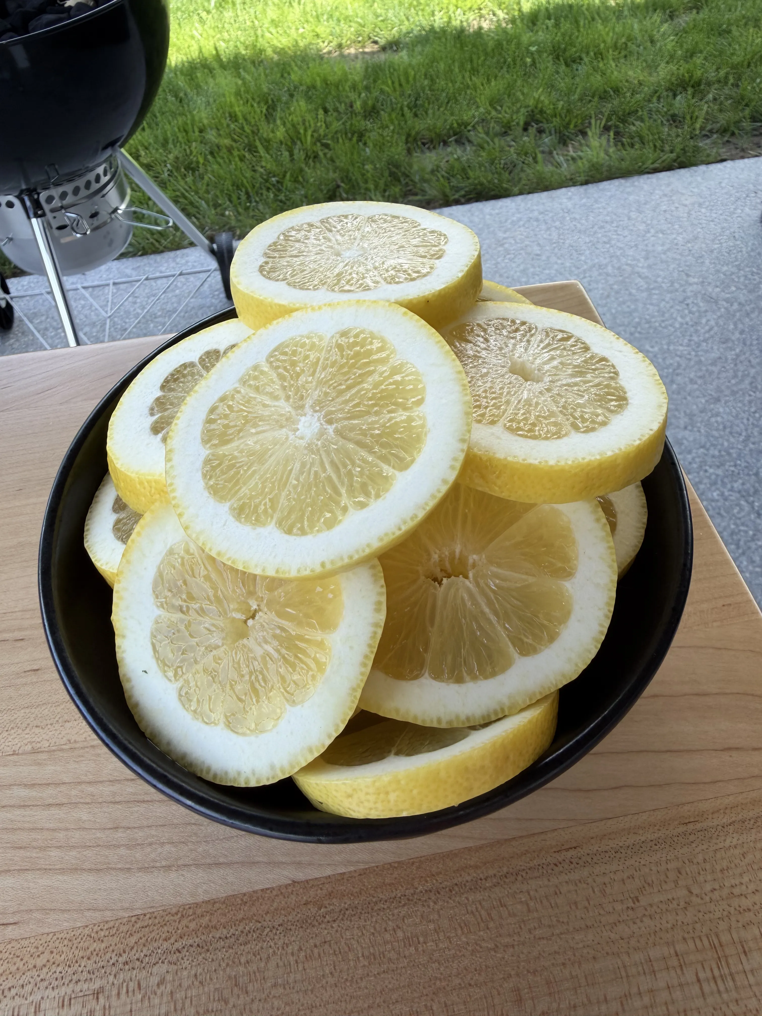 Fresh lemon slices in a black bowl ready for the hot honey smoked salmon