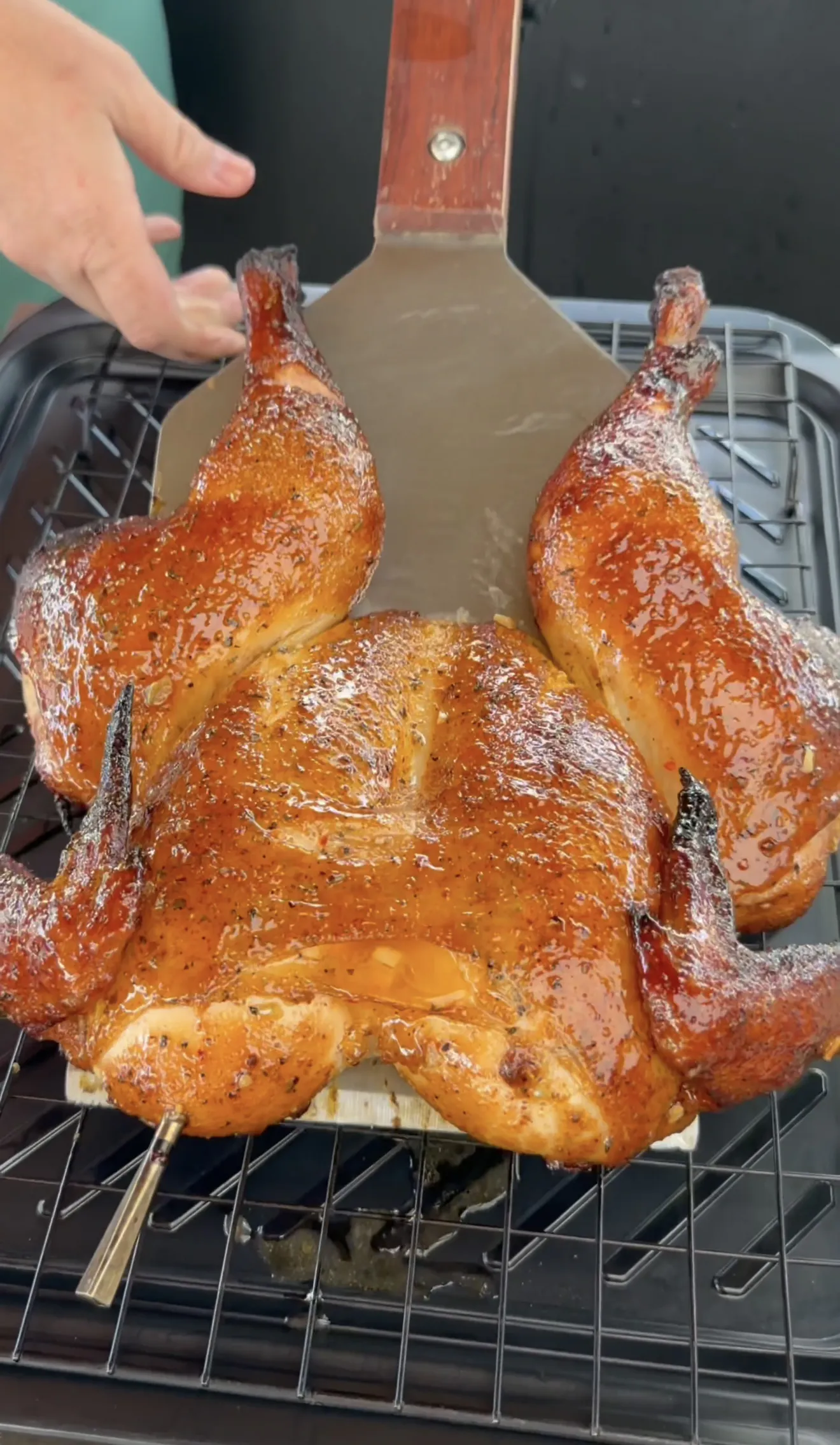 Two golden brown spatchcock chickens with crispy skin on grill grates