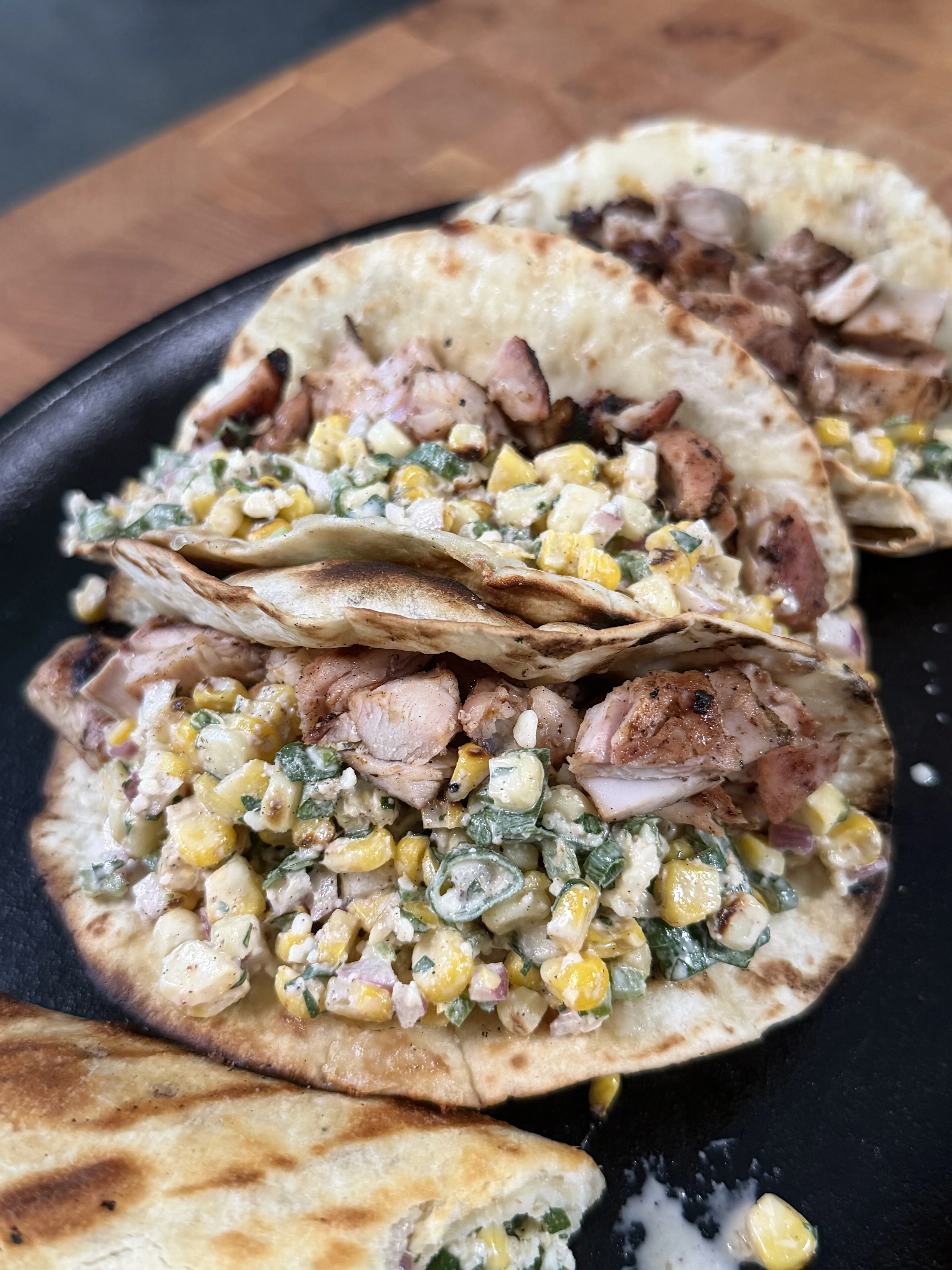 Assembled grilled chicken elote tacos in a cast iron skillet