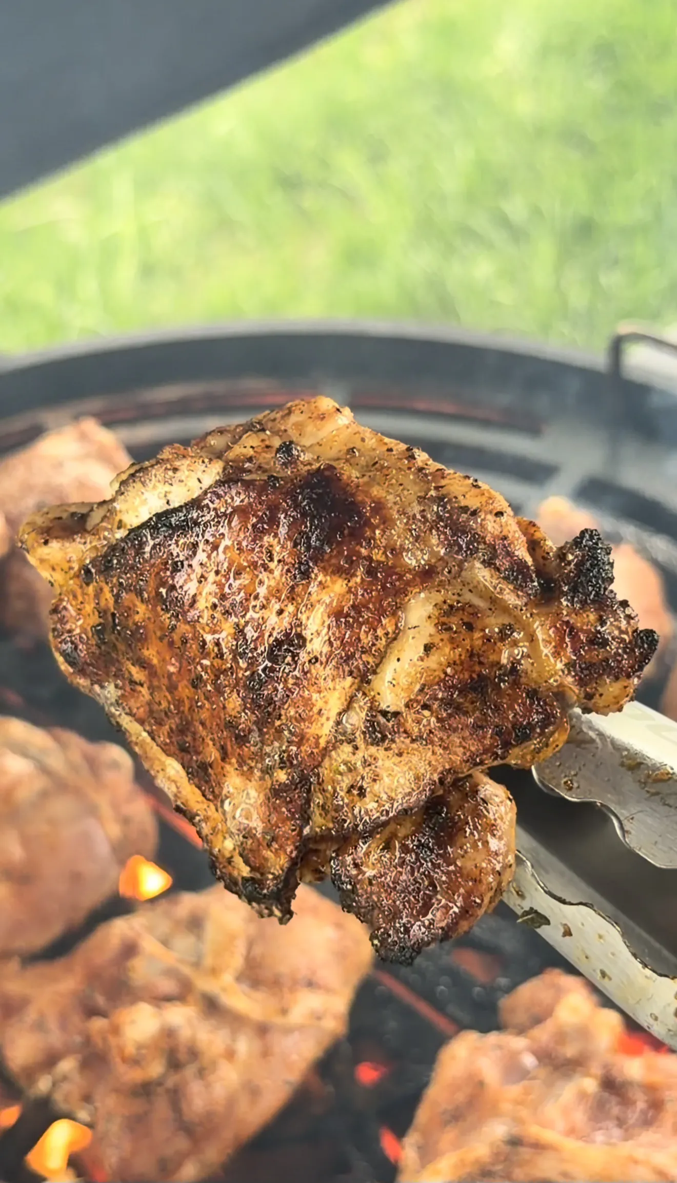 Bone-in chicken thighs searing skin-side down with charred skin developing