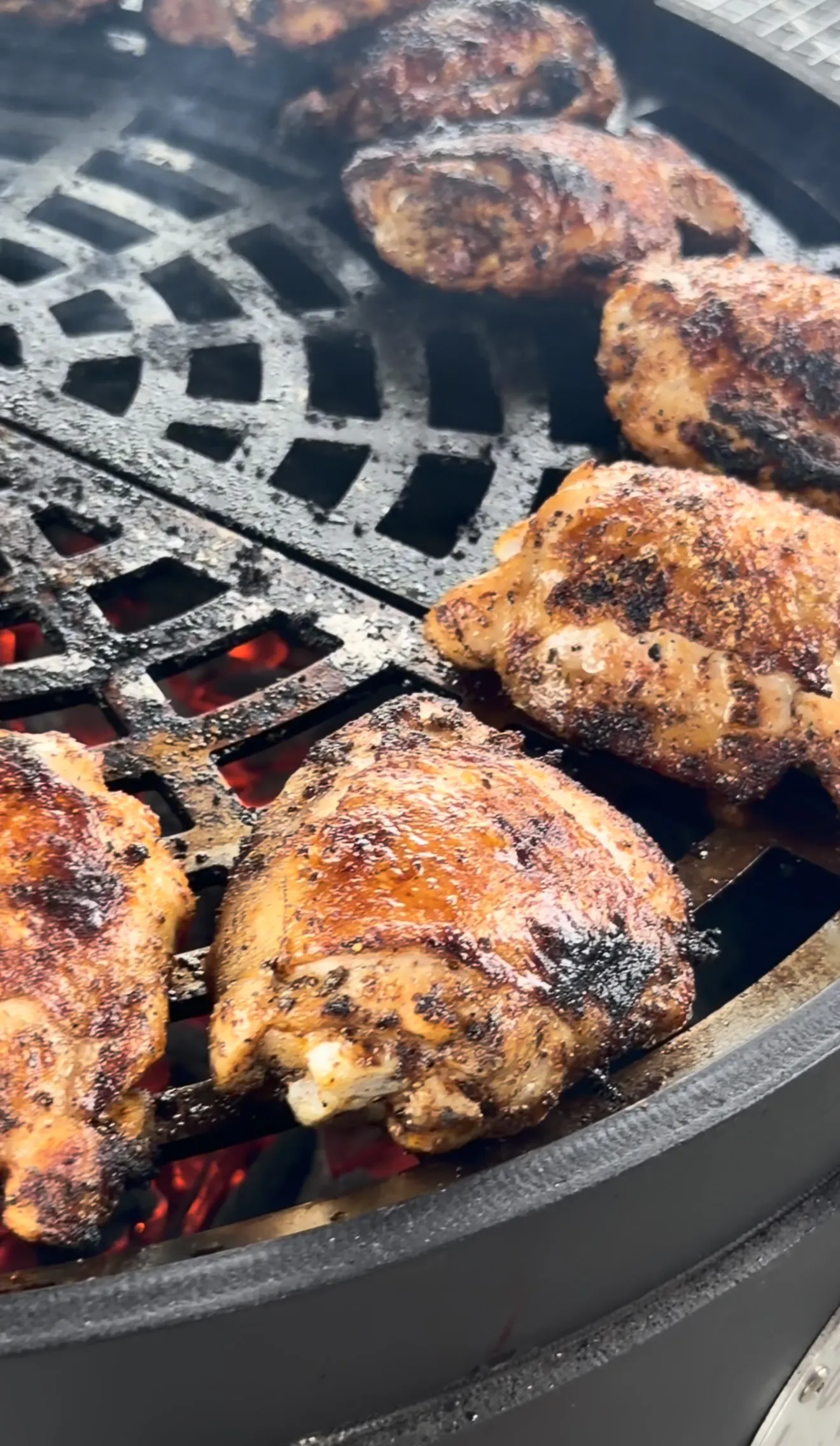 Bone-in skin-on chicken thighs searing skin-side down over direct grill flames