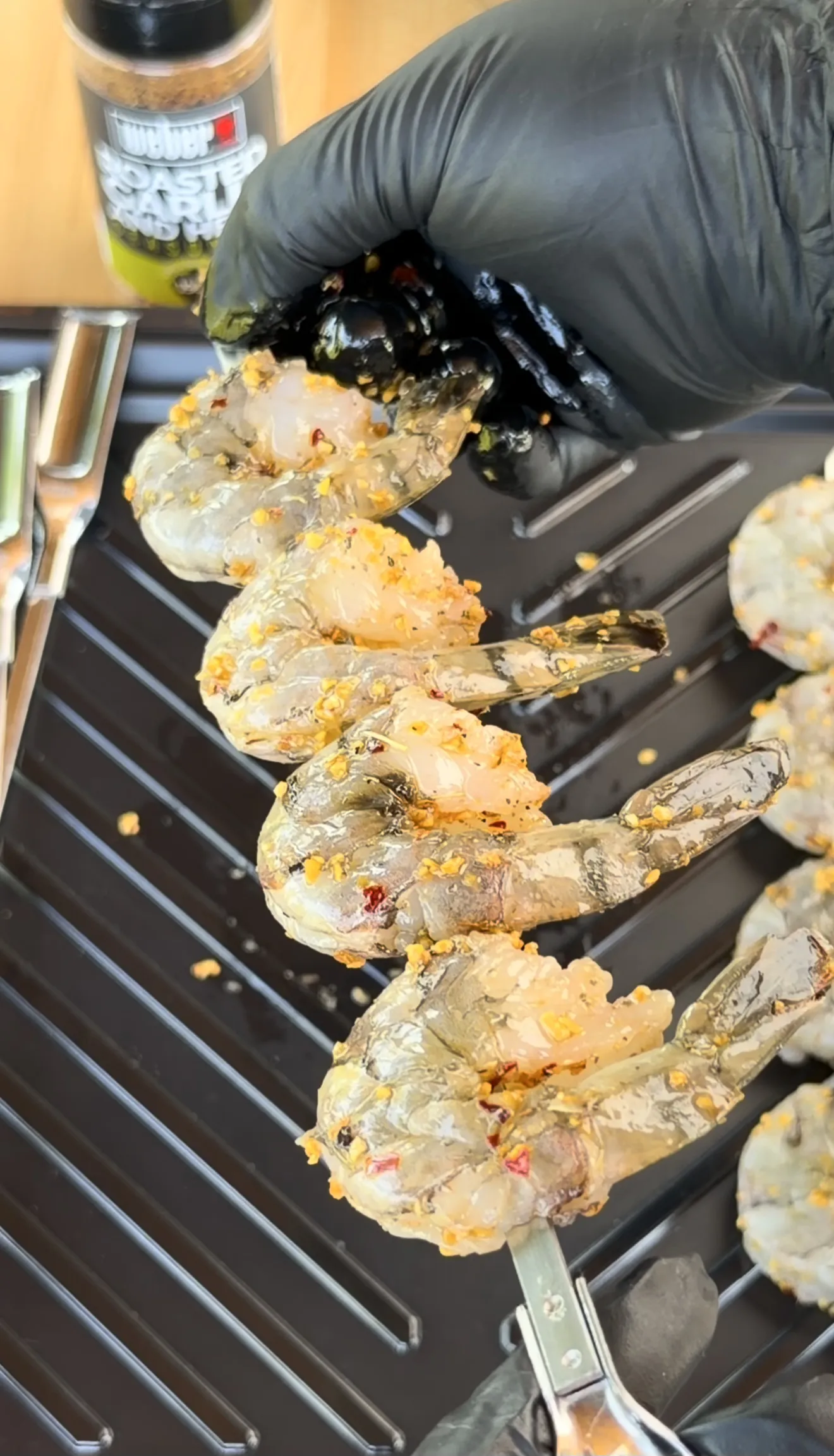 Grilled shrimp skewers cooking on grill grates with golden garlic herb seasoning