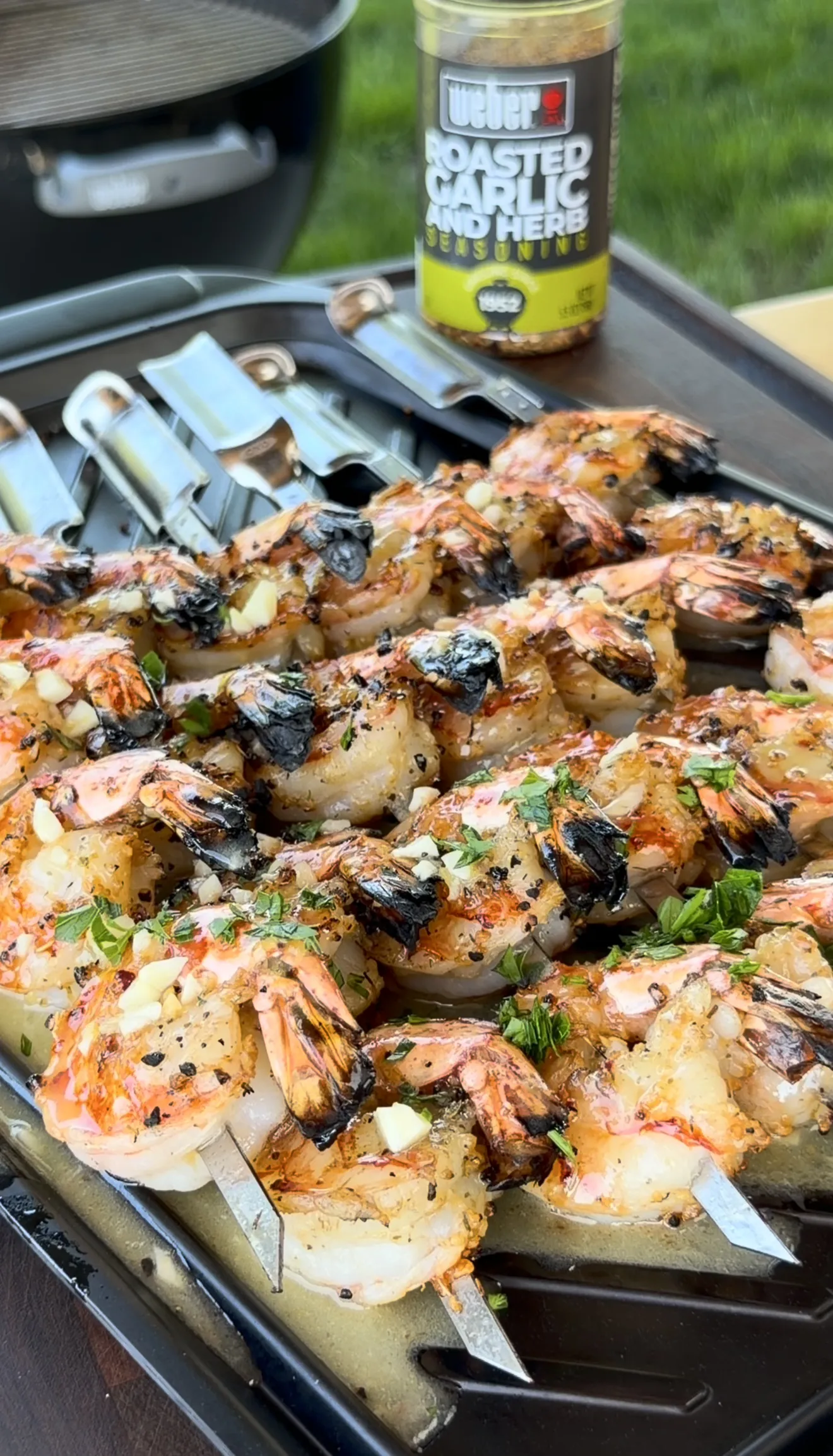 Grilled shrimp skewers with roasted garlic and fresh herbs on a grill pan ready to serve
