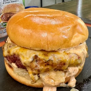 Juicy smoked Cajun burger with melted cheese and sauce on golden brioche bun
