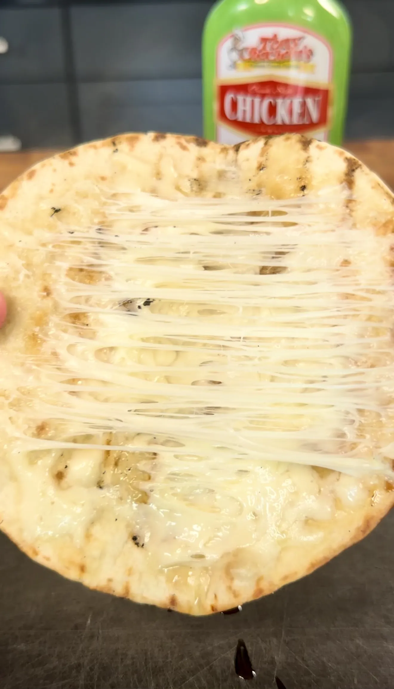 Flour tortilla with stretching melted cheese strings for grilled chicken elote tacos