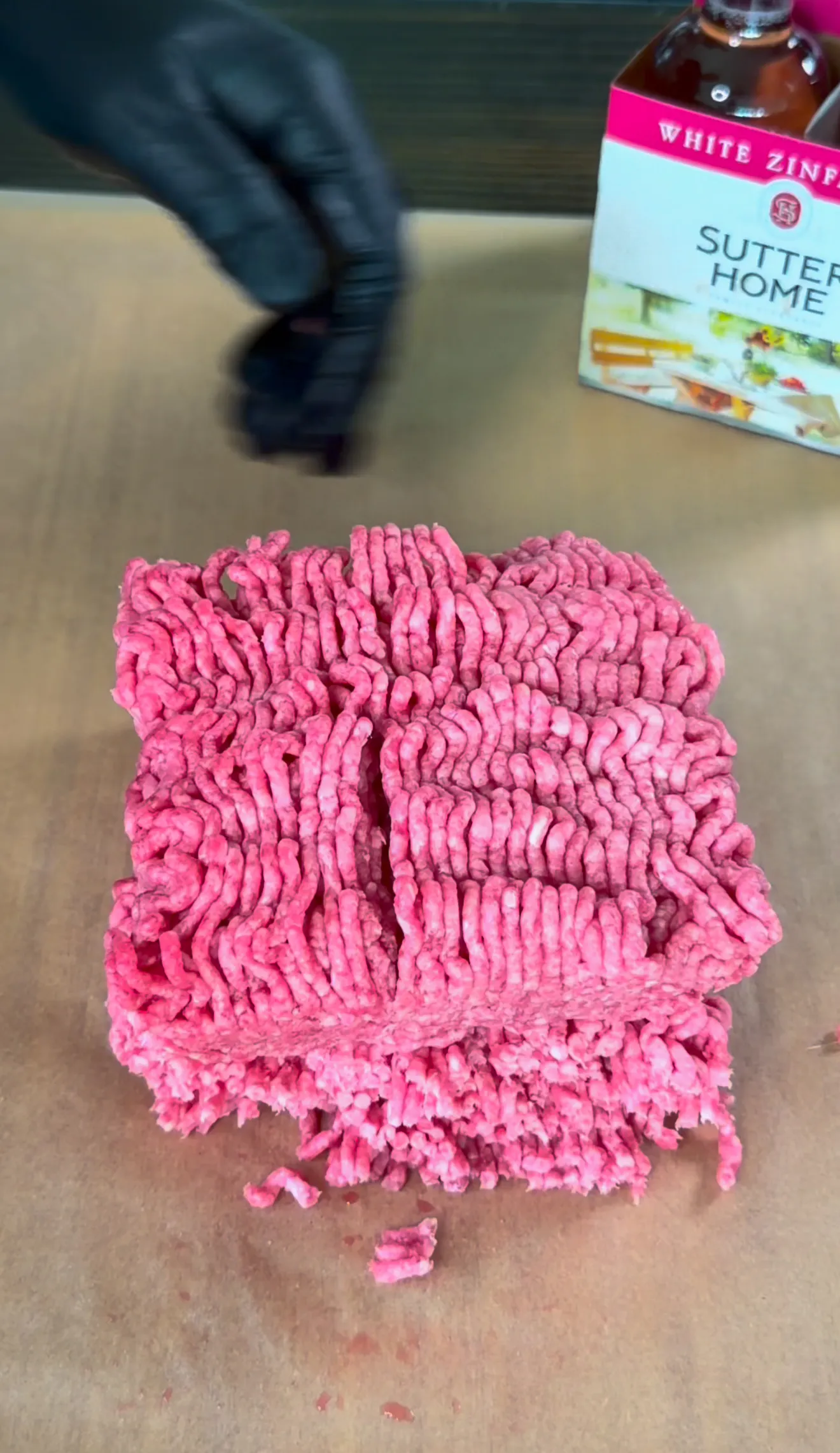 Raw ground beef formed into patties on cutting board ready for making bacon jam smash burgers