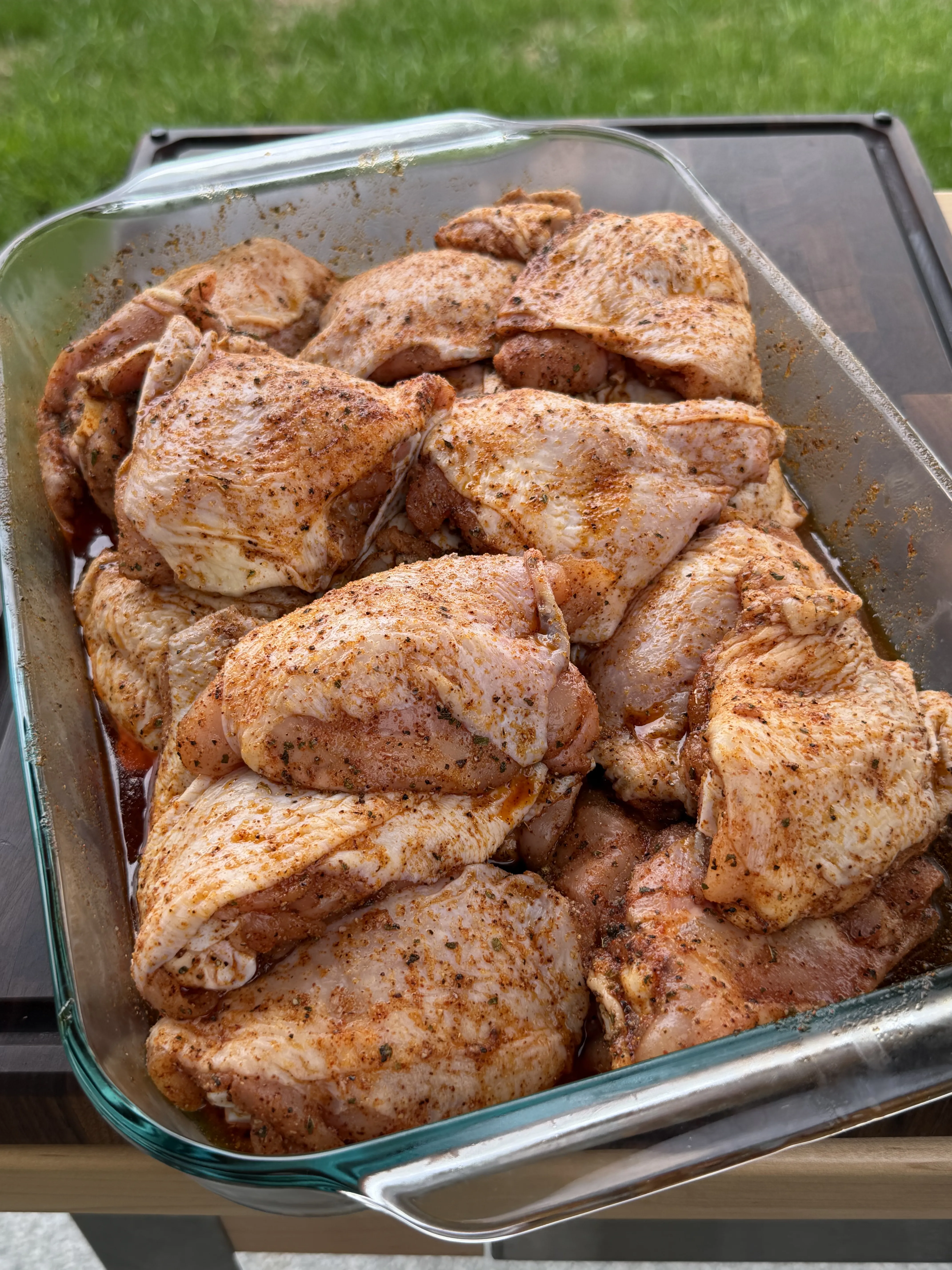 Seasoned bone-in chicken thighs air-chilling uncovered in a glass baking dish