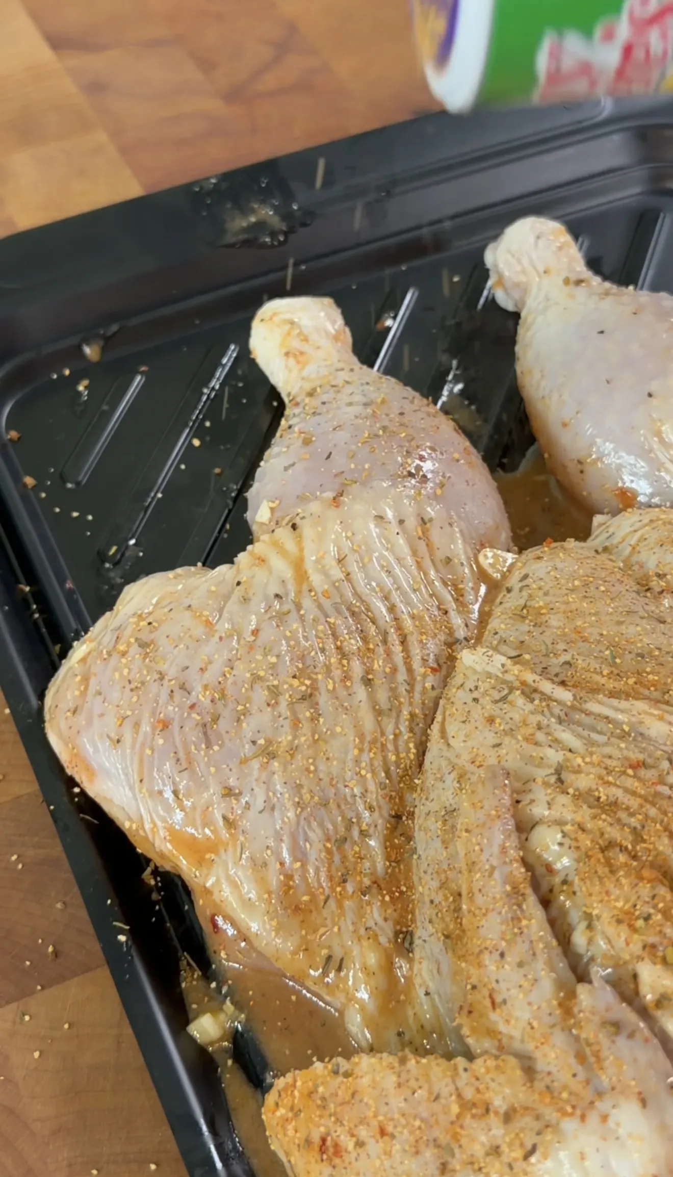 Seasoned spatchcock chicken with herbs and spices on a grill pan ready for smoking