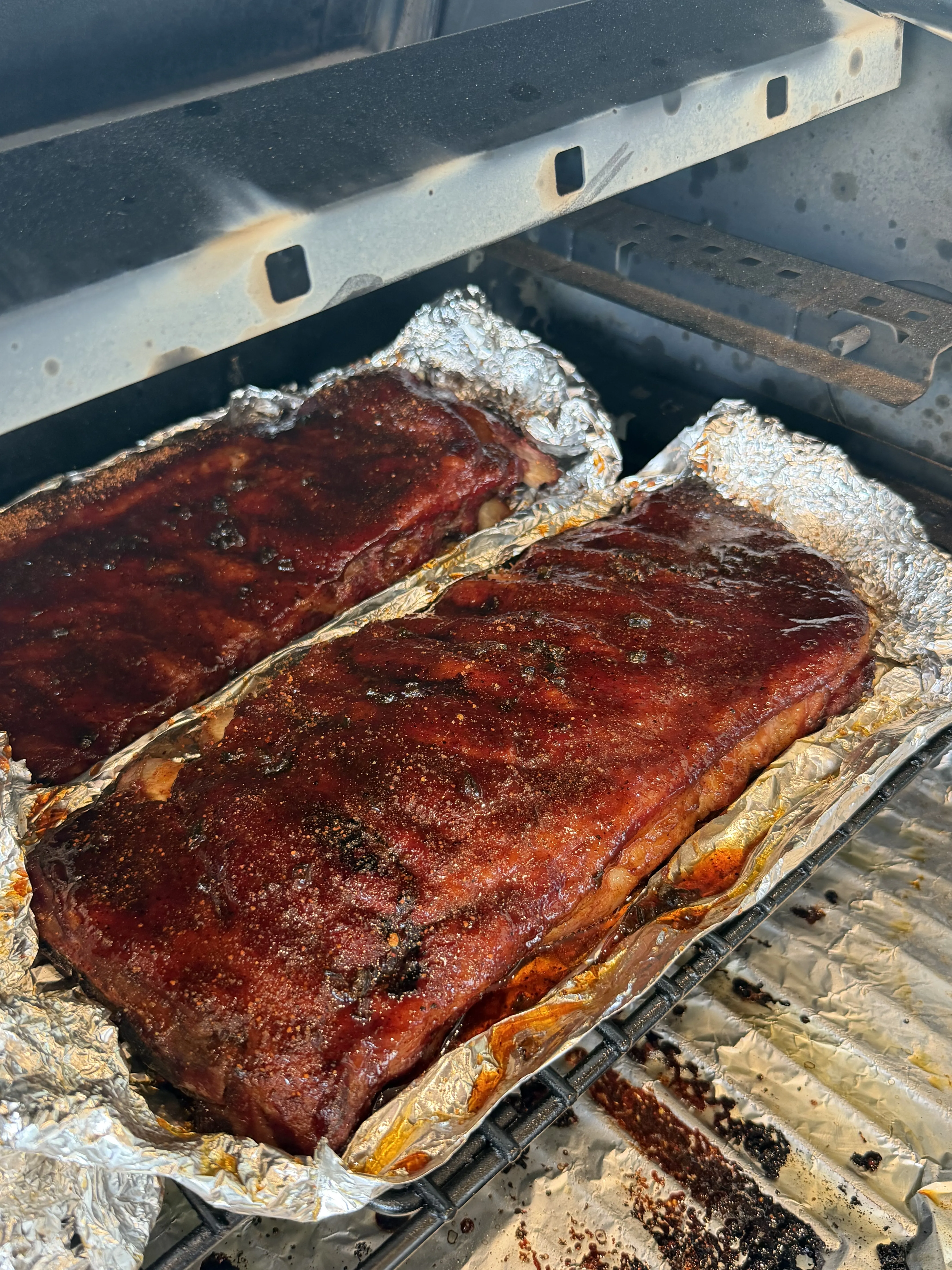 Smoked ribs wrapped in foil on a pellet grill