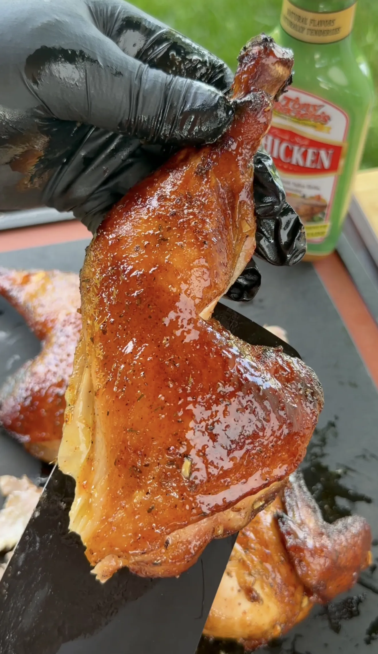 Smoked spatchcock chicken being carved on a cutting board