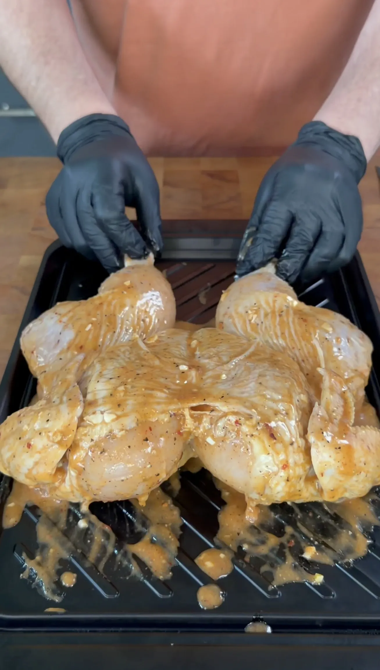 Seasoned spatchcock chicken being prepared on a grill rack
