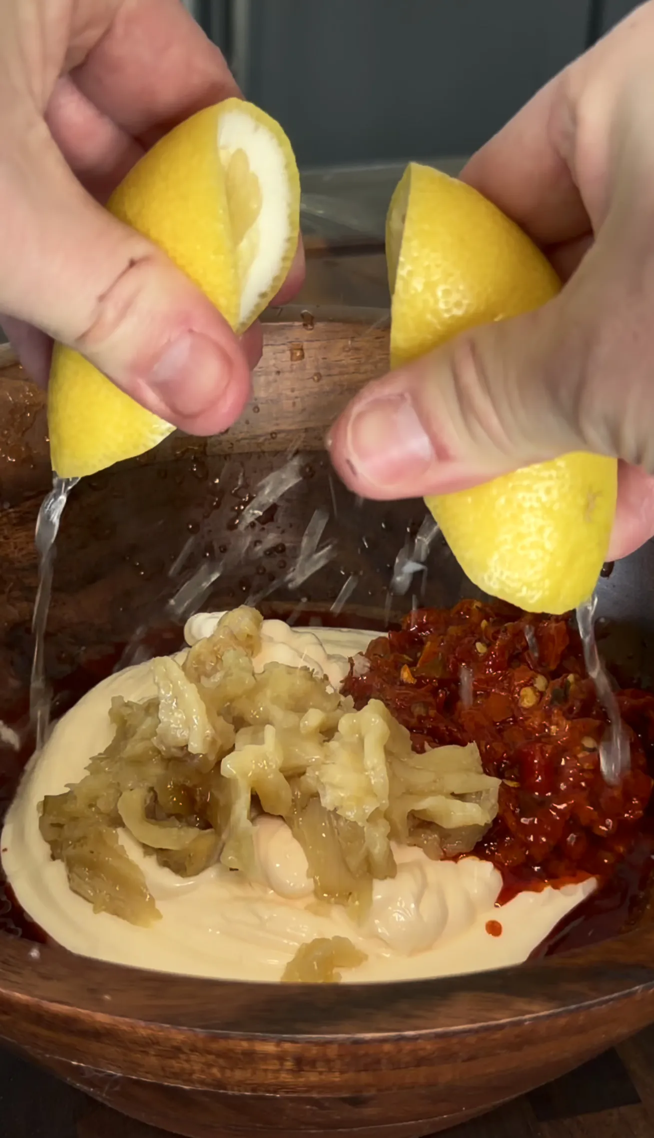 Squeezing fresh lemon juice over a crispy chicken cutlet sandwich