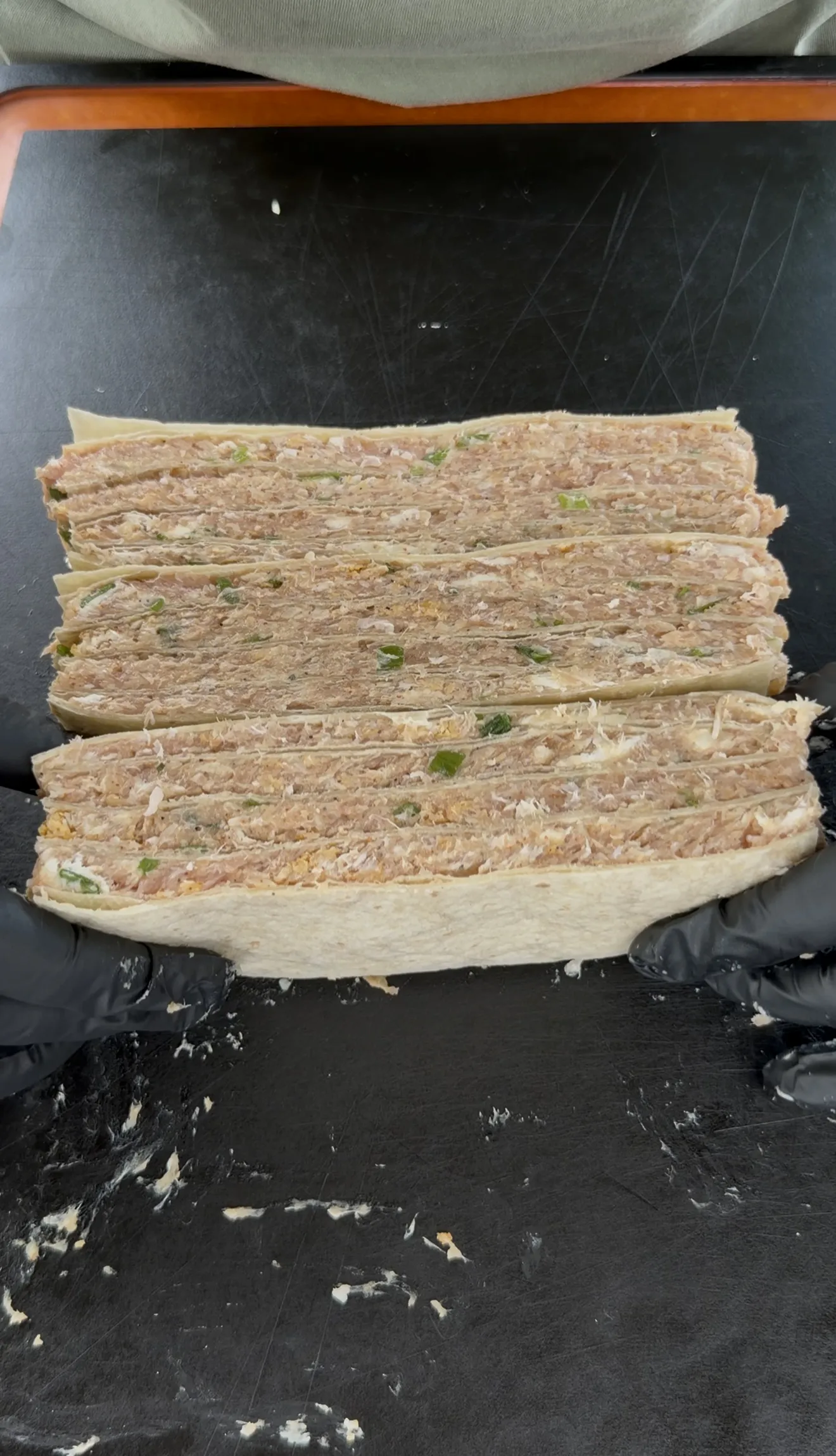 Chilled buffalo chicken tortilla stack sliced into strips for skewering