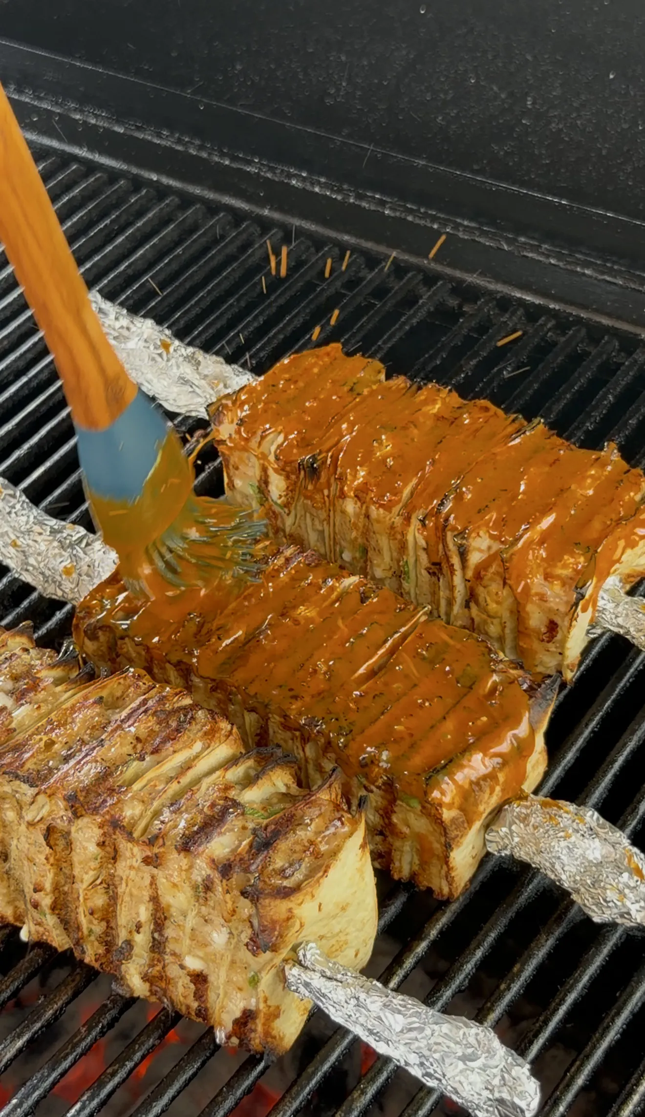 Buffalo chicken tortilla kebabs brushed with buffalo butter while grilling