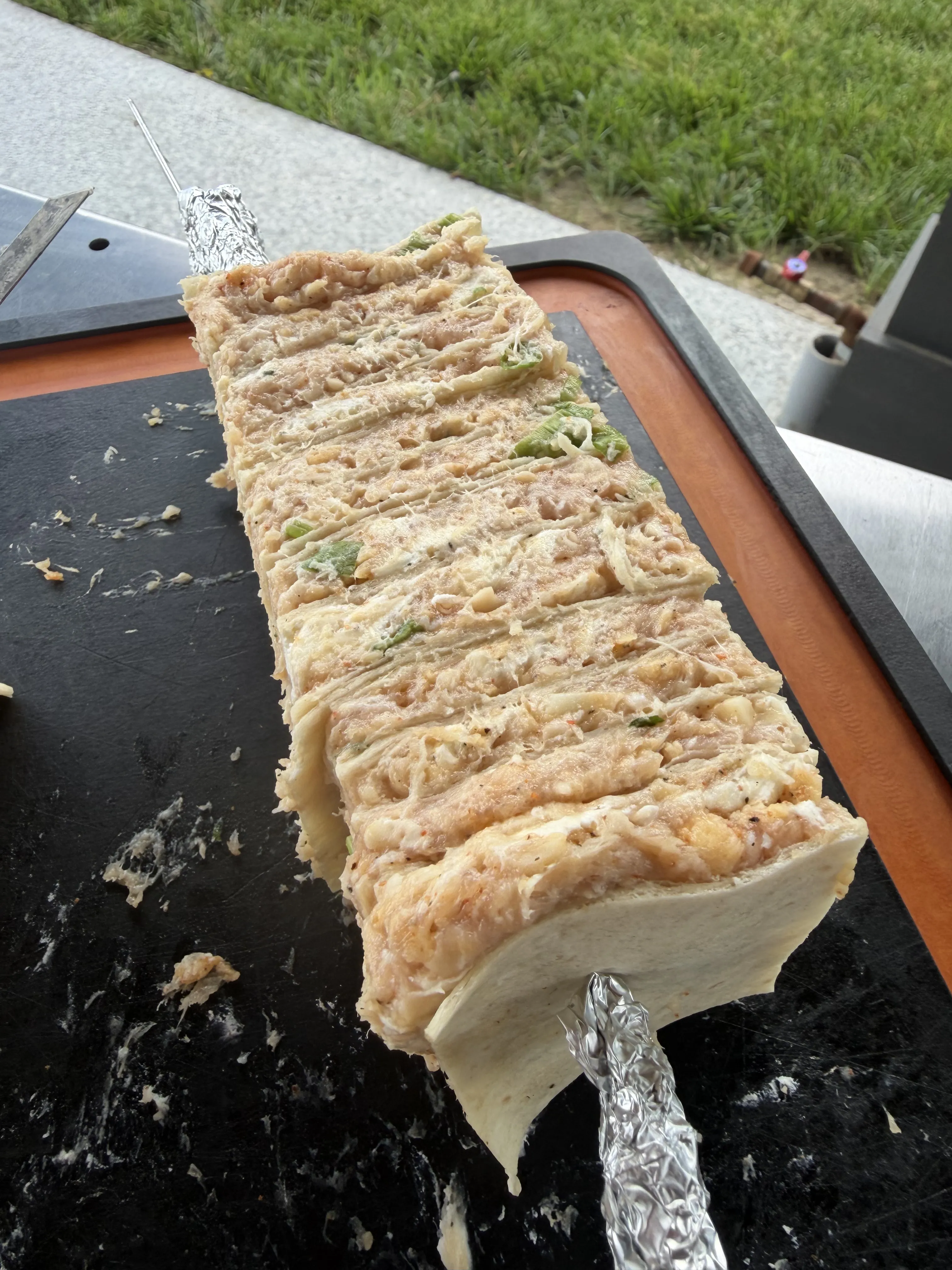Buffalo chicken tortilla kebab cut through the center showing the layered filling