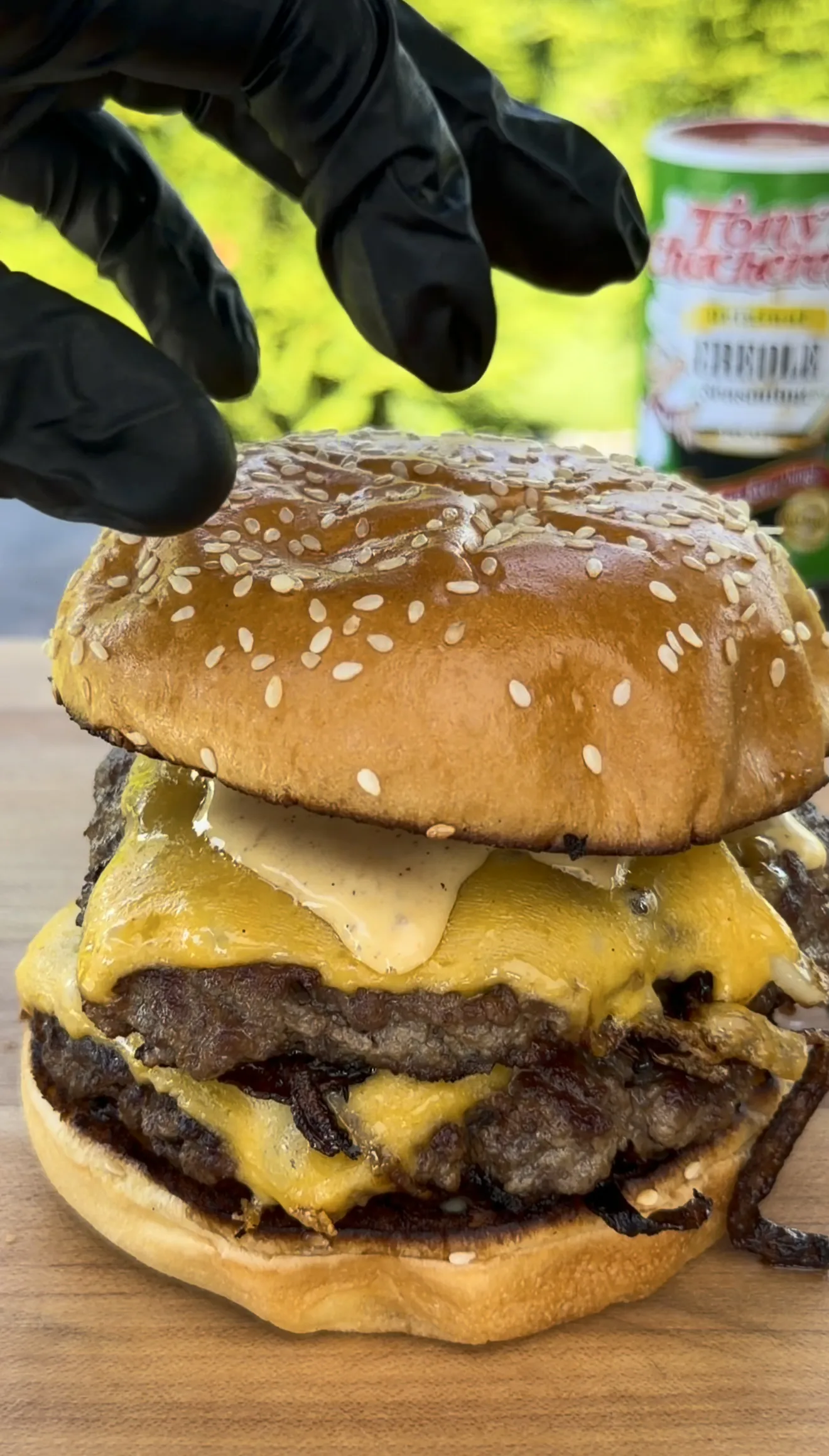 Cajun Oklahoma onion smash burger double stacked with melted cheese and crispy onions on a brioche bun