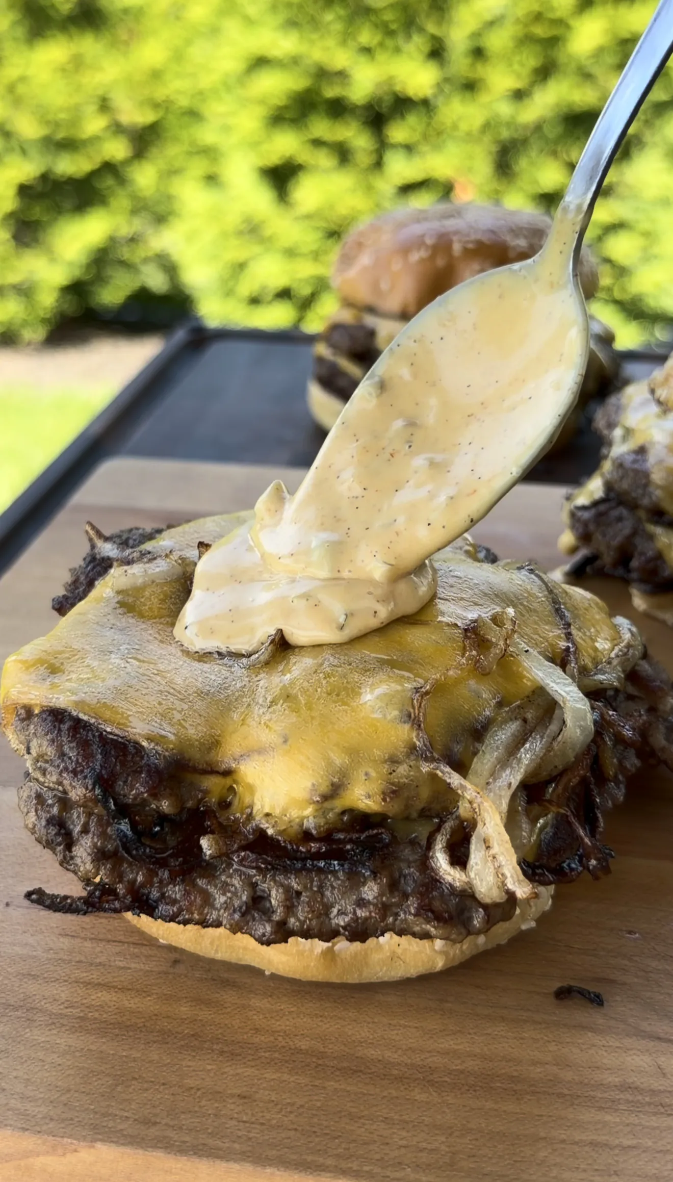 Cajun burger sauce drizzled over the stacked Oklahoma onion smash burger