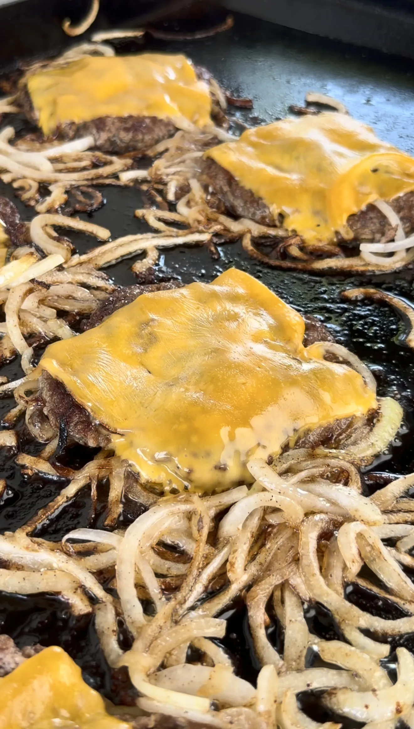 Cajun Oklahoma smash burgers with melted cheese and crispy caramelized onion edges