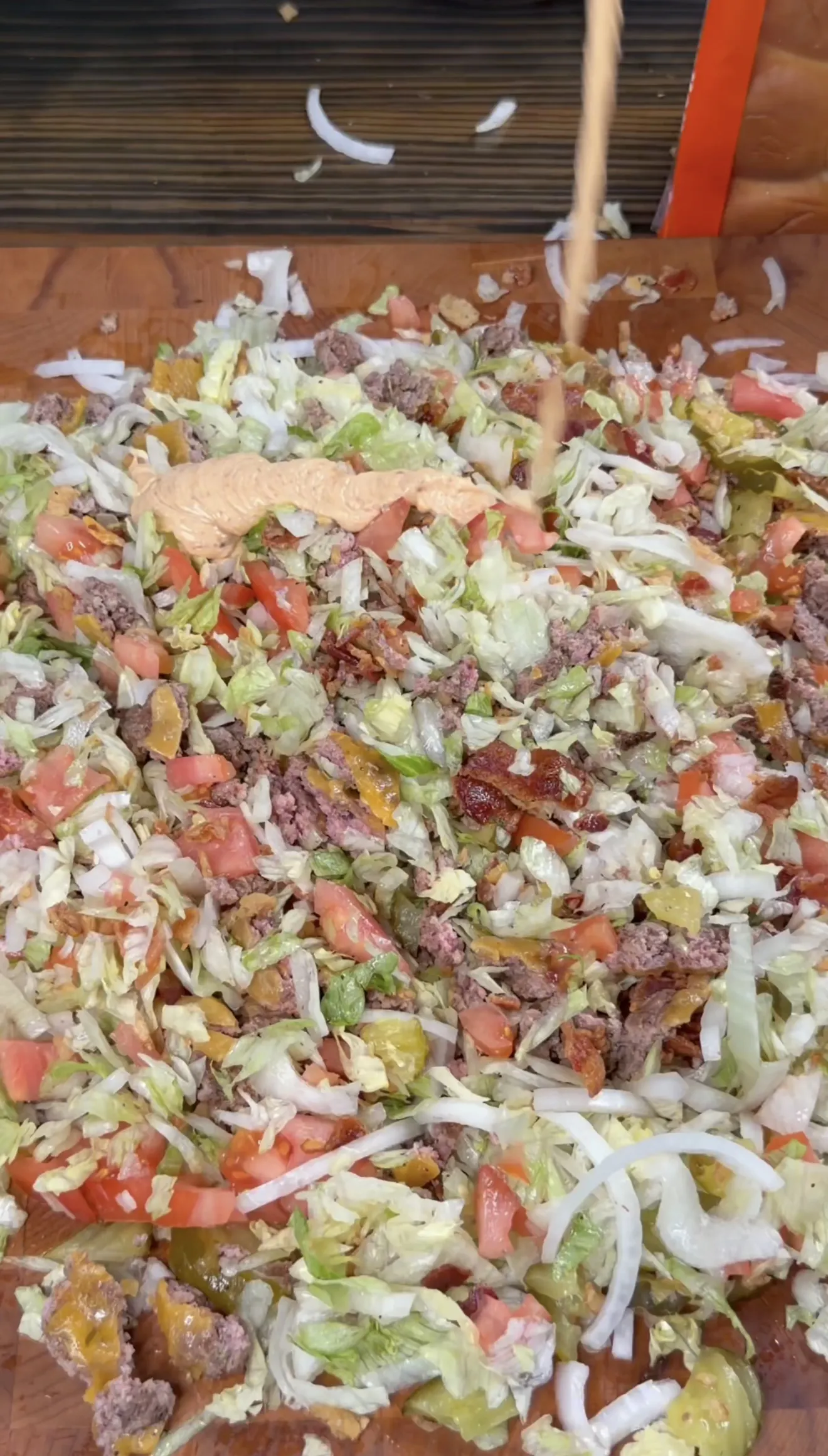 Chopped cheeseburger ingredients with beef, lettuce, tomato, onion, pickles, and special sauce
