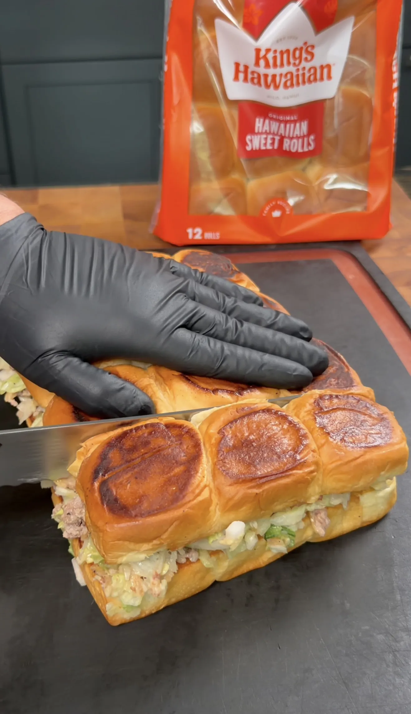 Toasted King's Hawaiian cheeseburger sliders being sliced into individual portions