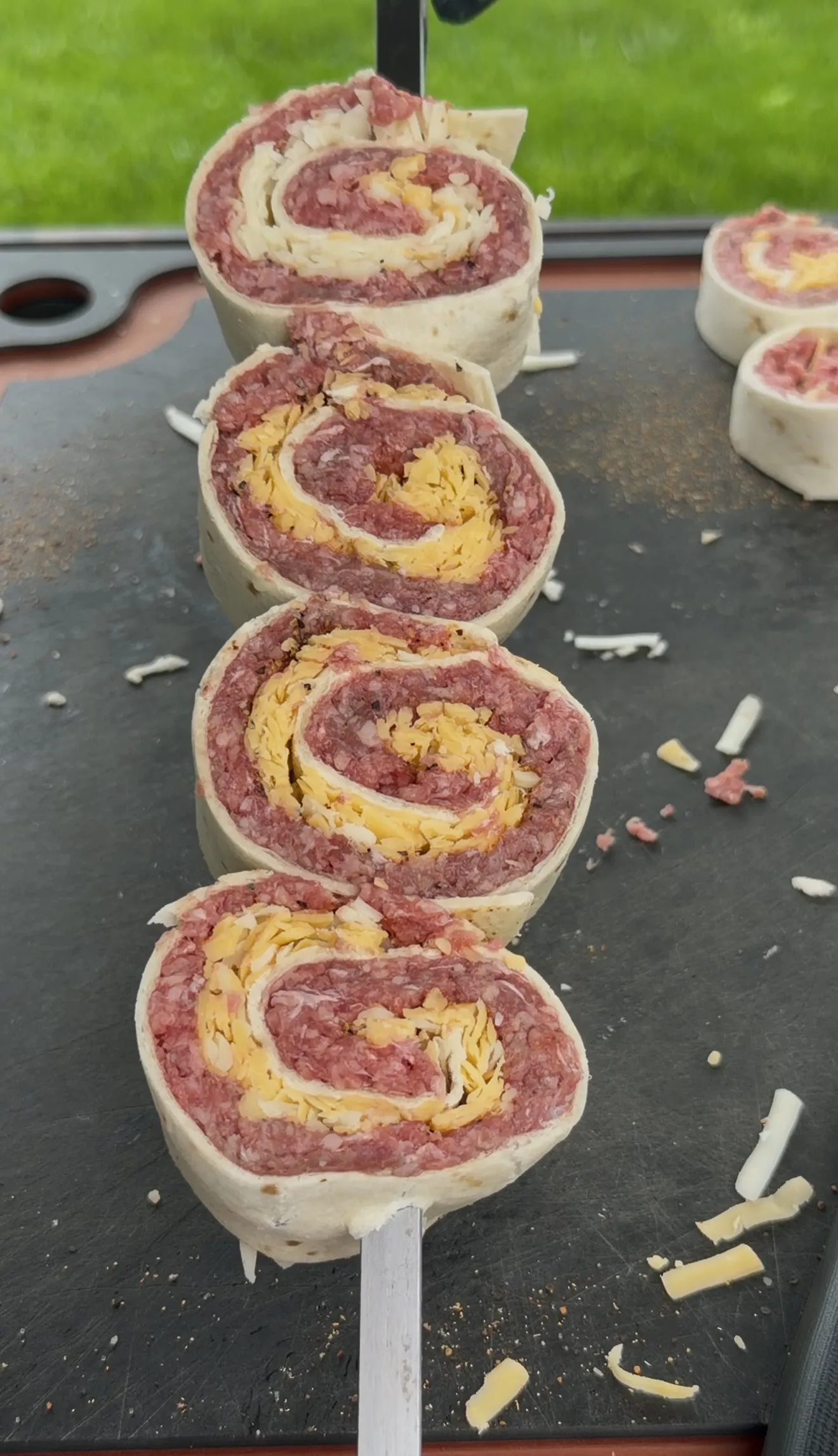 Sliced beef and cheese tortilla pinwheels stacked on a skewer