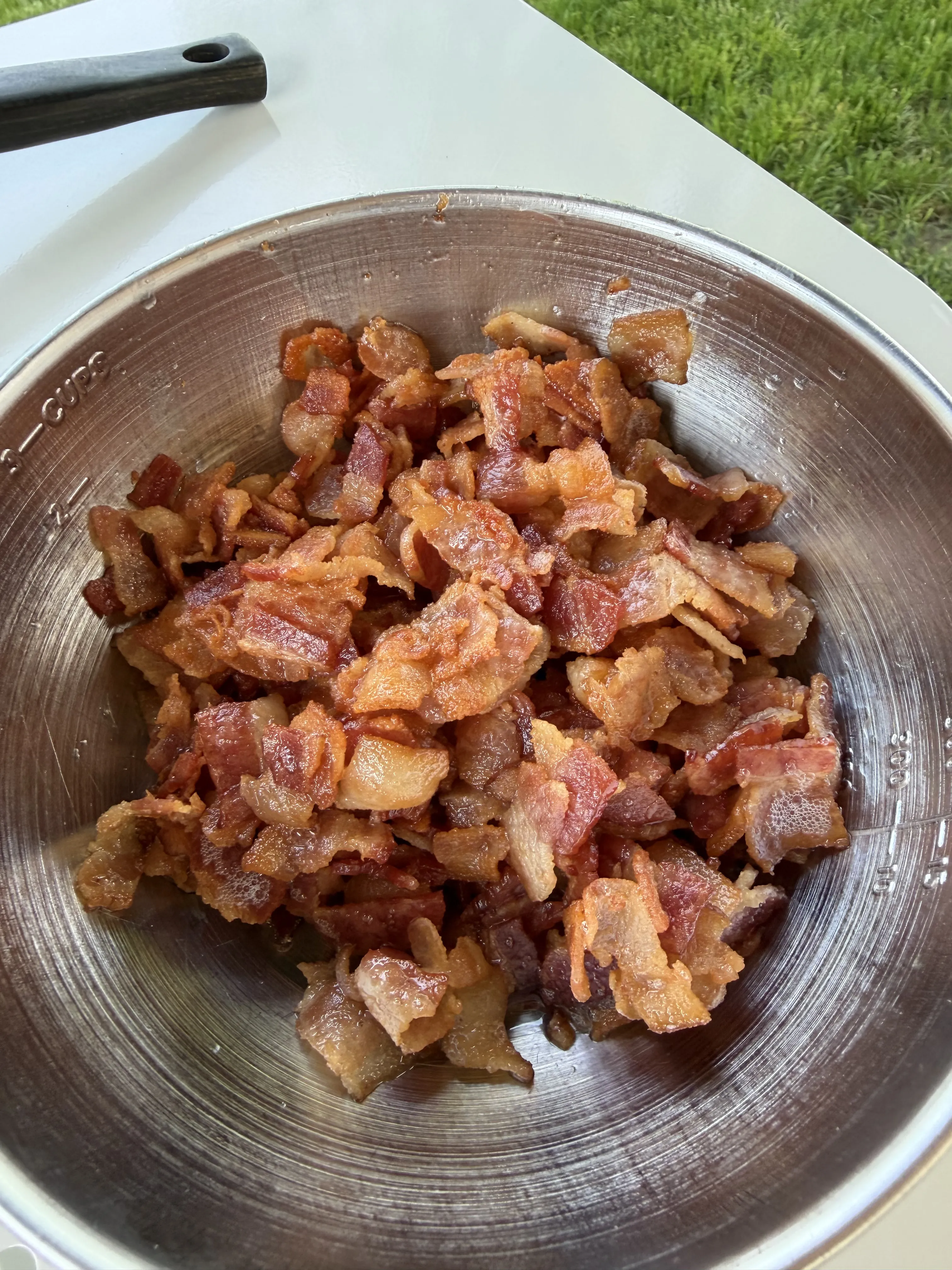 Crispy cooked bacon pieces in a metal bowl ready for the molasses bacon jam