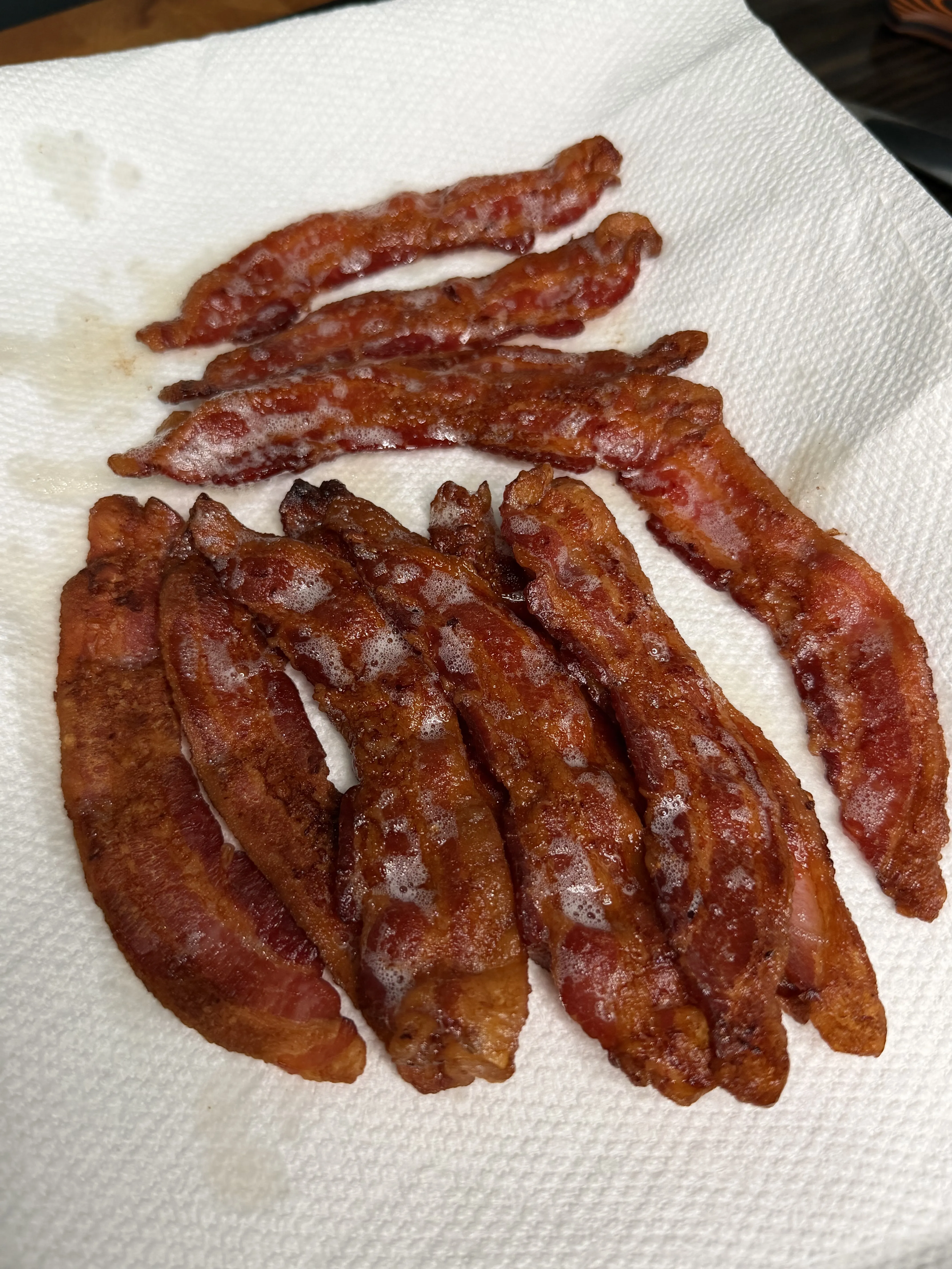 Crispy cooked bacon strips draining on paper towels for the chopped cheeseburger sliders