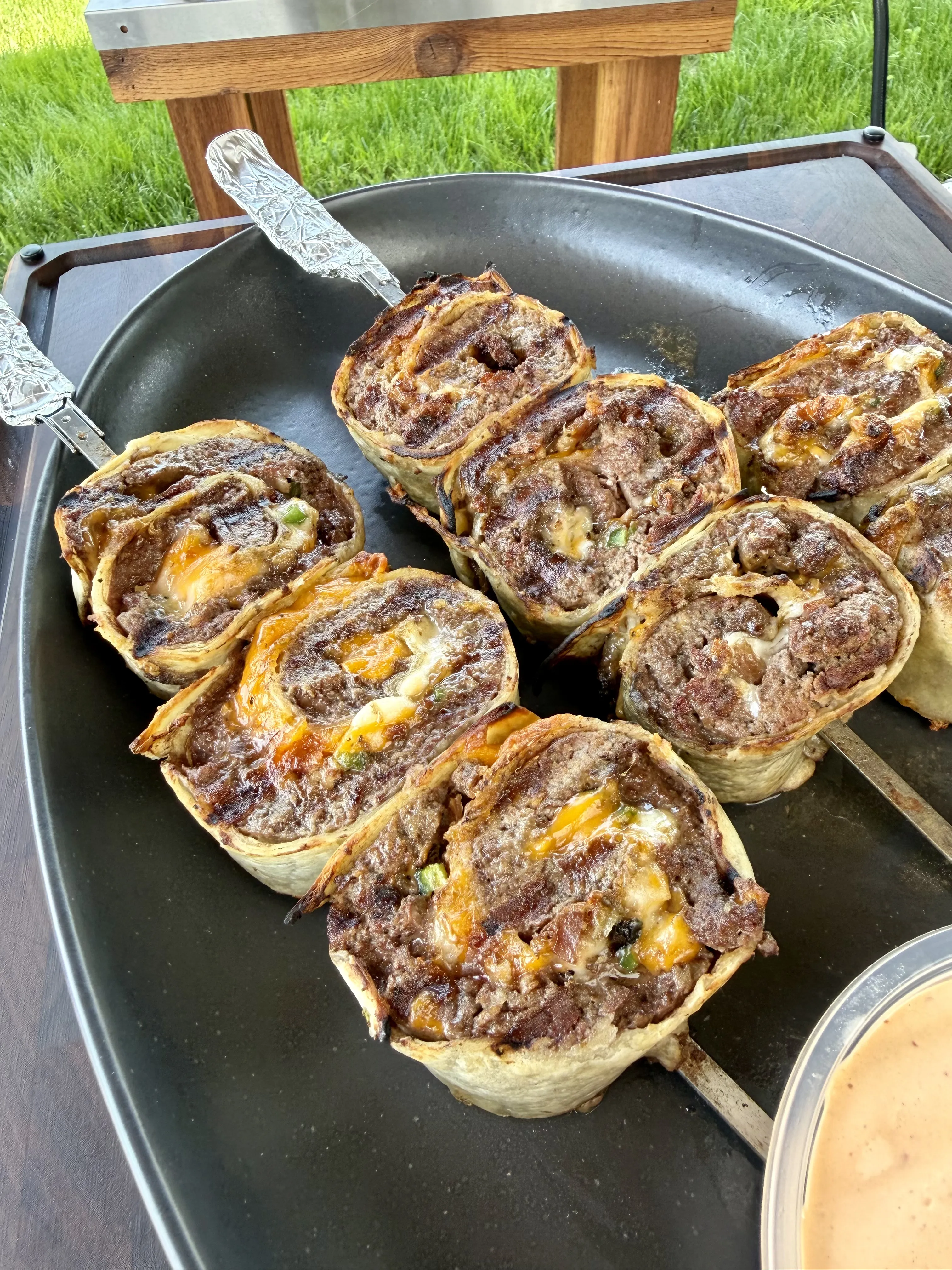 Golden brown jalapeño bacon beef pinwheels showing crispy spiral layers