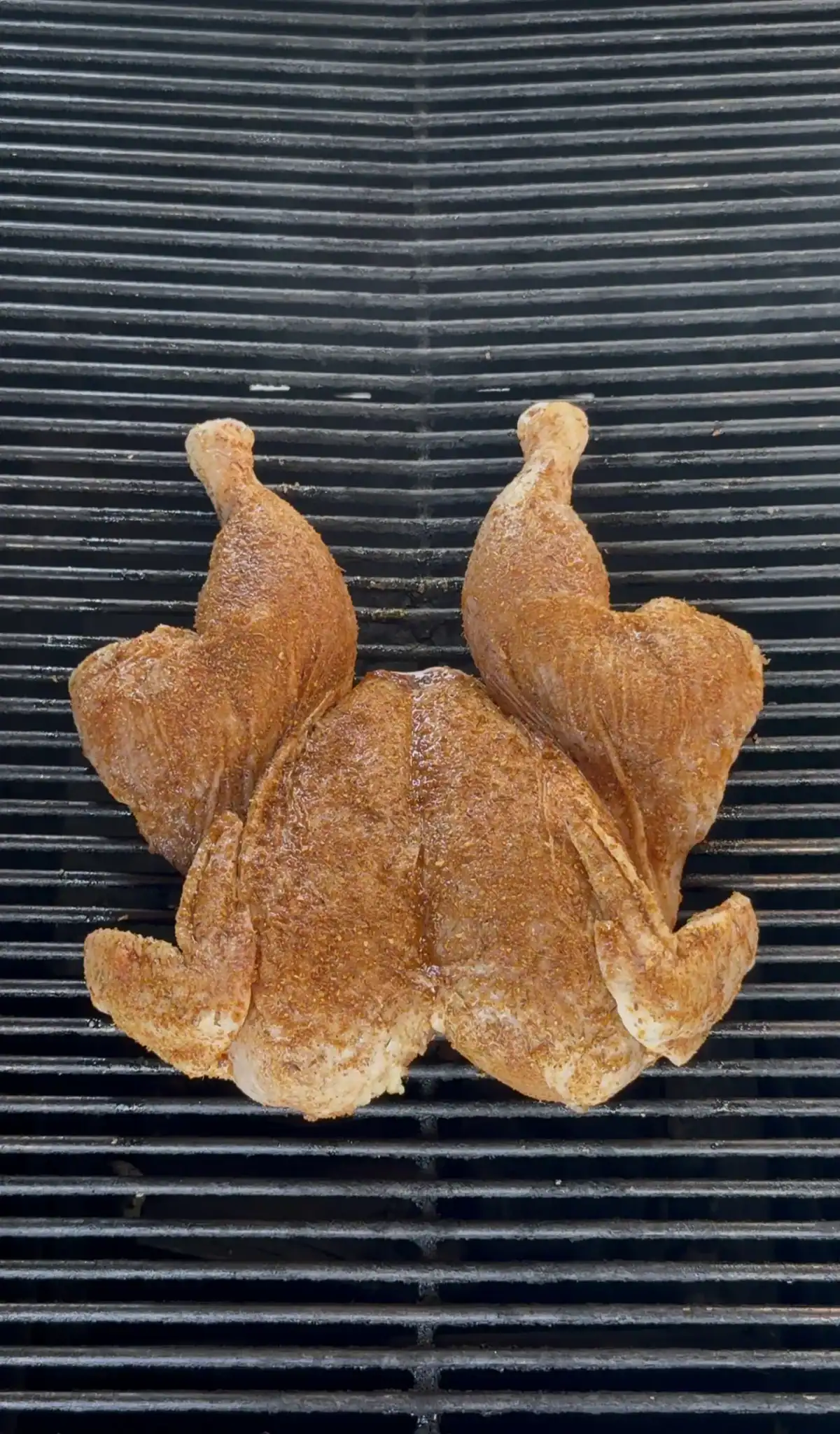 Lemon garlic herb spatchcock chicken with crispy golden skin on the grill grates