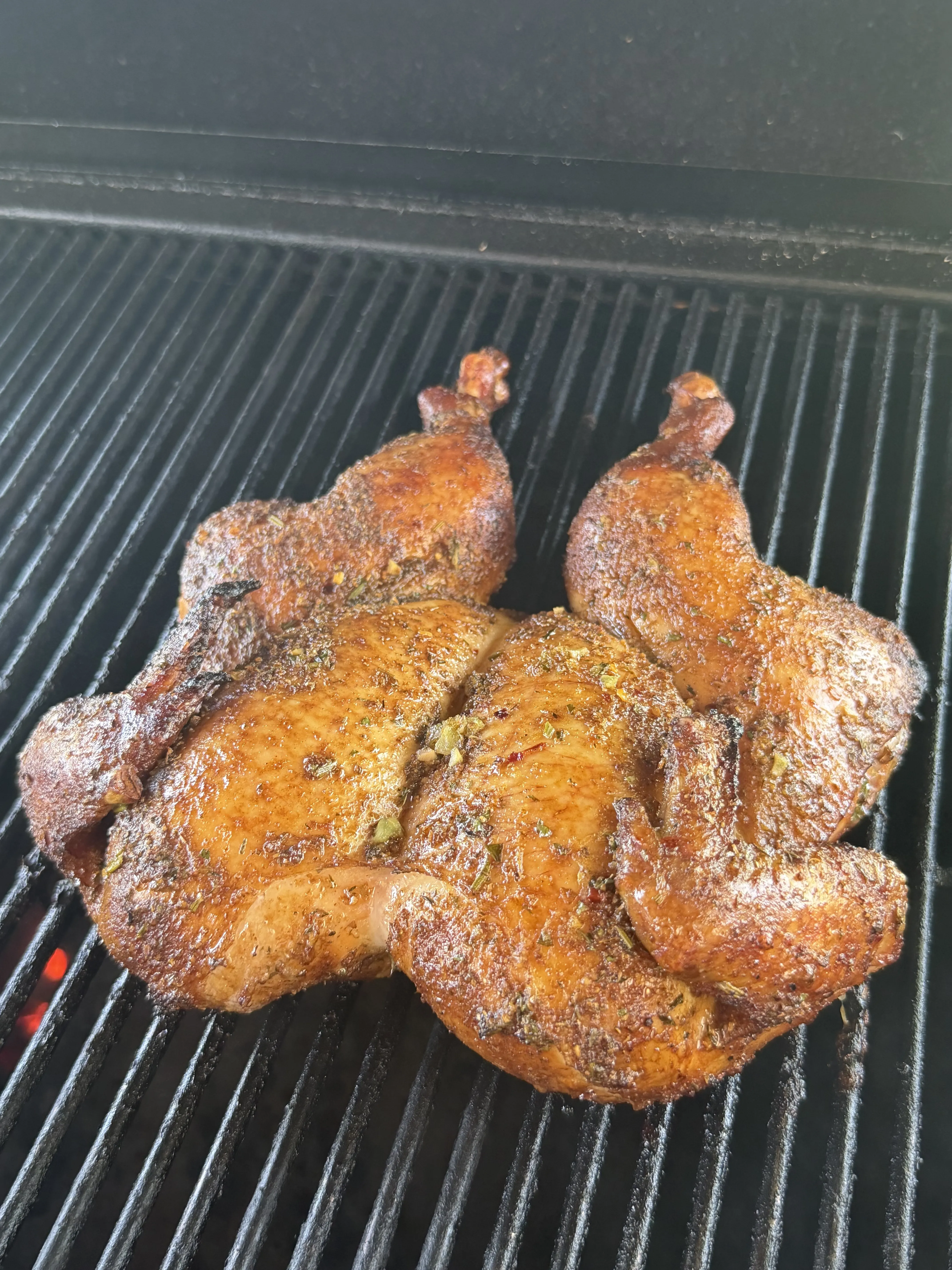 Lemon garlic herb spatchcock chicken developing crispy golden skin on the grill