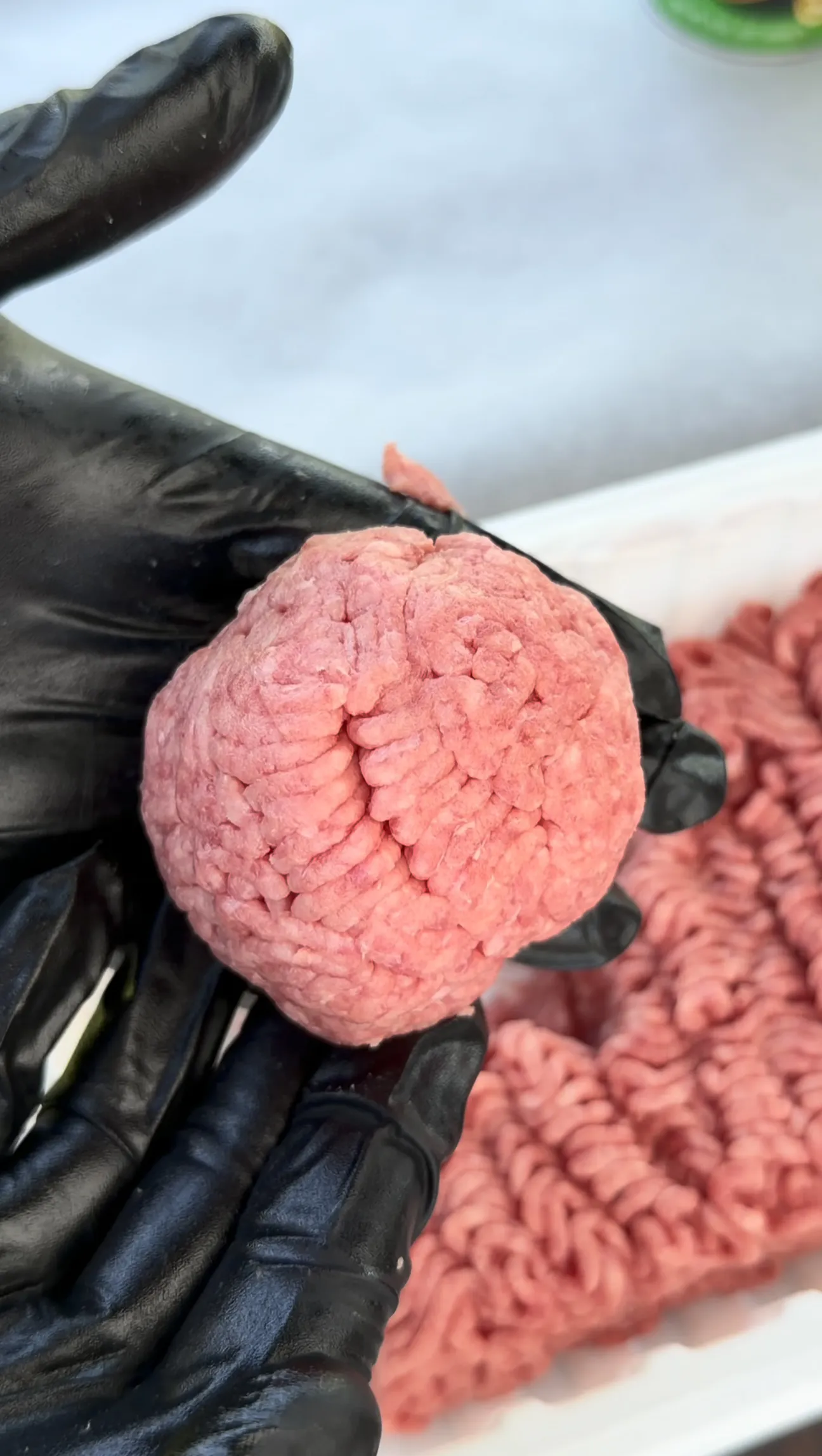 Loosely packed 80/20 ground beef ball formed for an Oklahoma onion smash burger