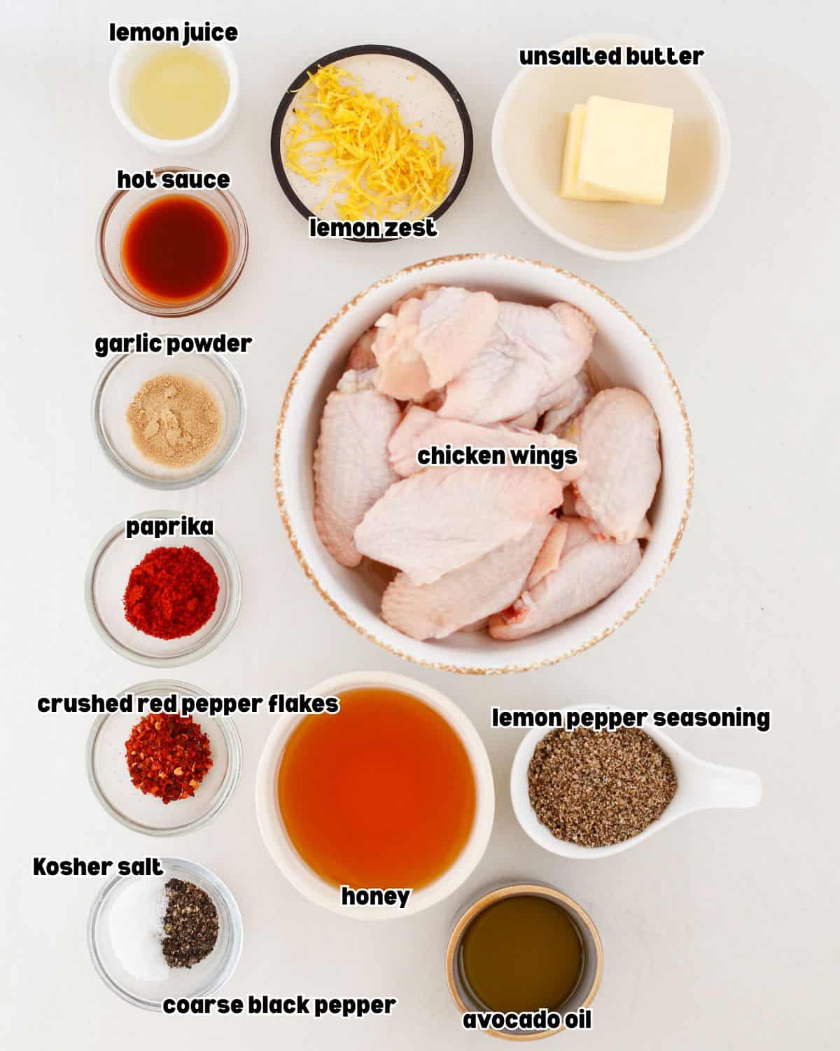 ingredients for grilled hot honey lemon pepper wings, including chicken wings, lemon pepper seasoning, honey, hot sauce, butter, lemon and seasonings.