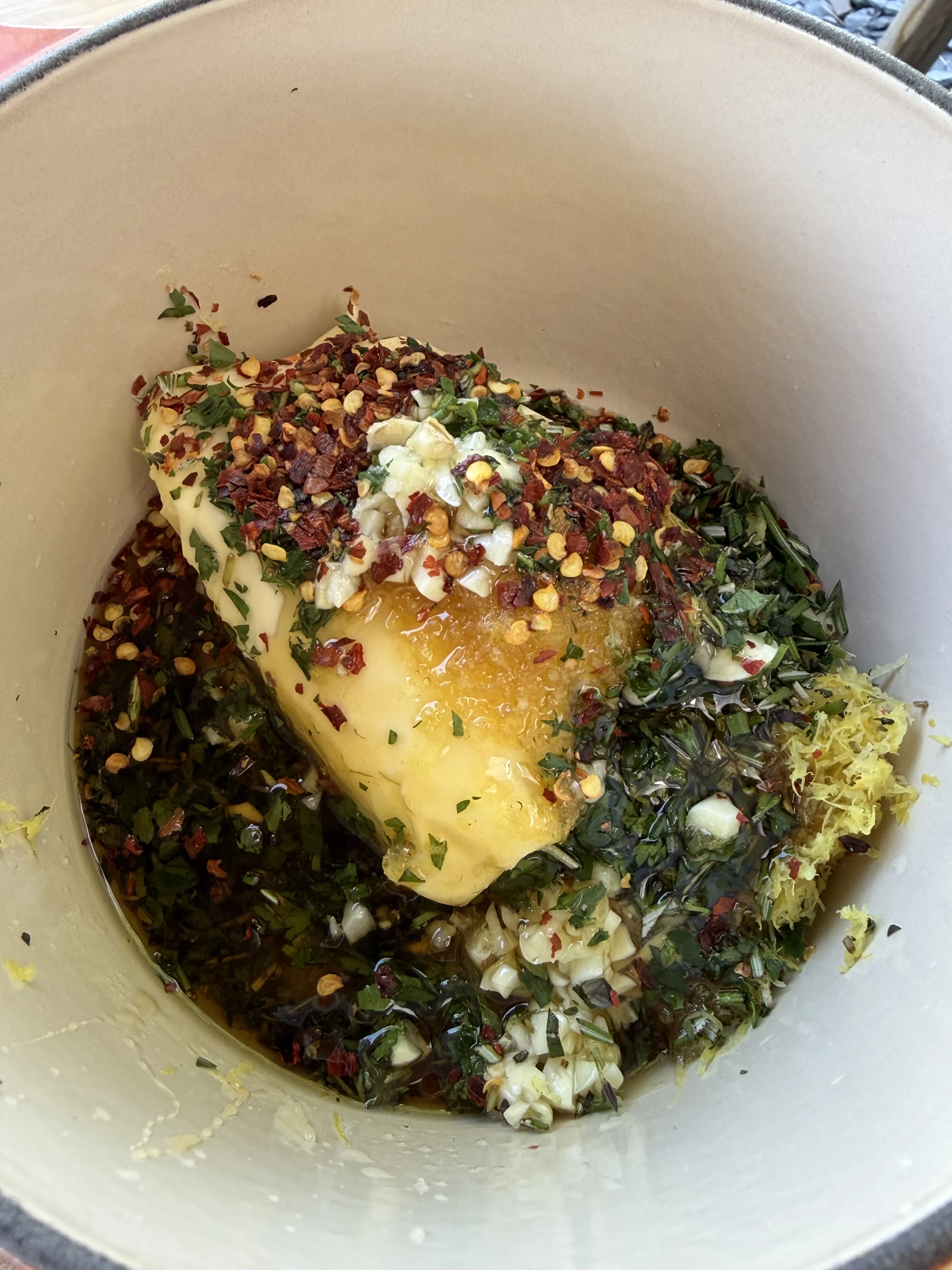 Lemon garlic herb compound butter prepared in a bowl ready to spread under and over the chicken skin