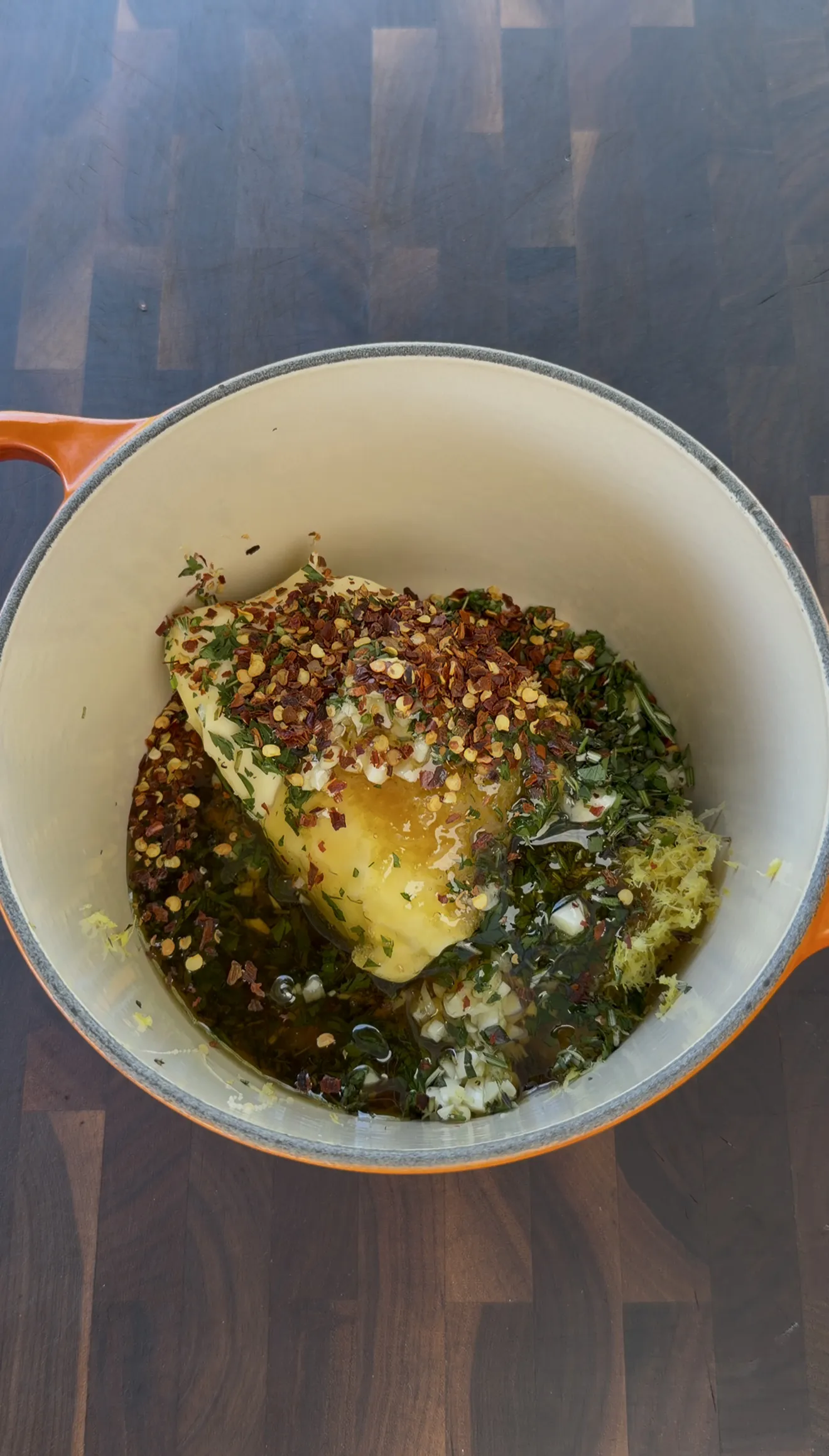 Spatchcocked chicken being prepared with the lemon garlic herb compound butter and seasonings
