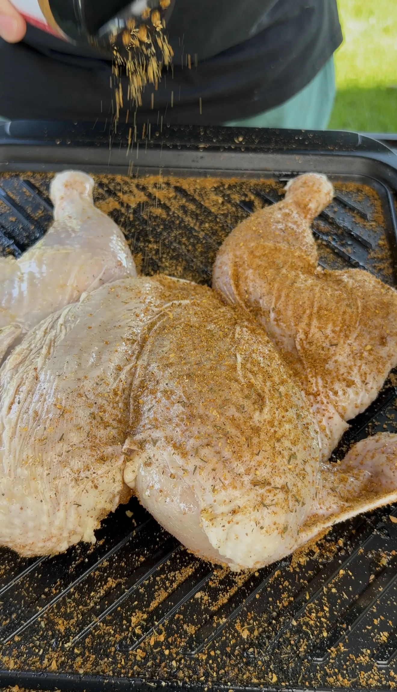 Spatchcocked chicken fully seasoned and ready for indirect grilling