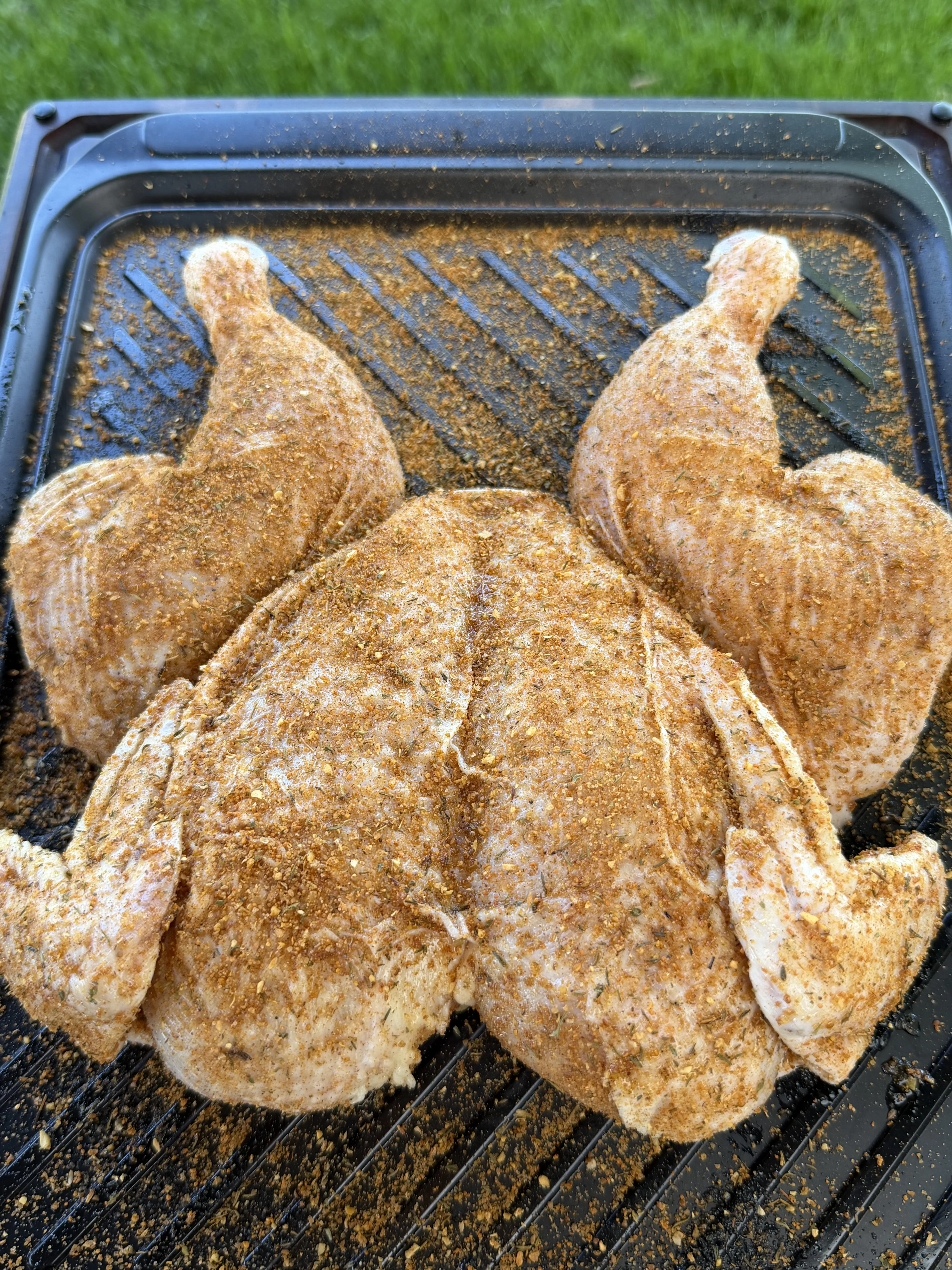 Seasoned spatchcock chicken placed on the grill for indirect cooking at 375 degrees