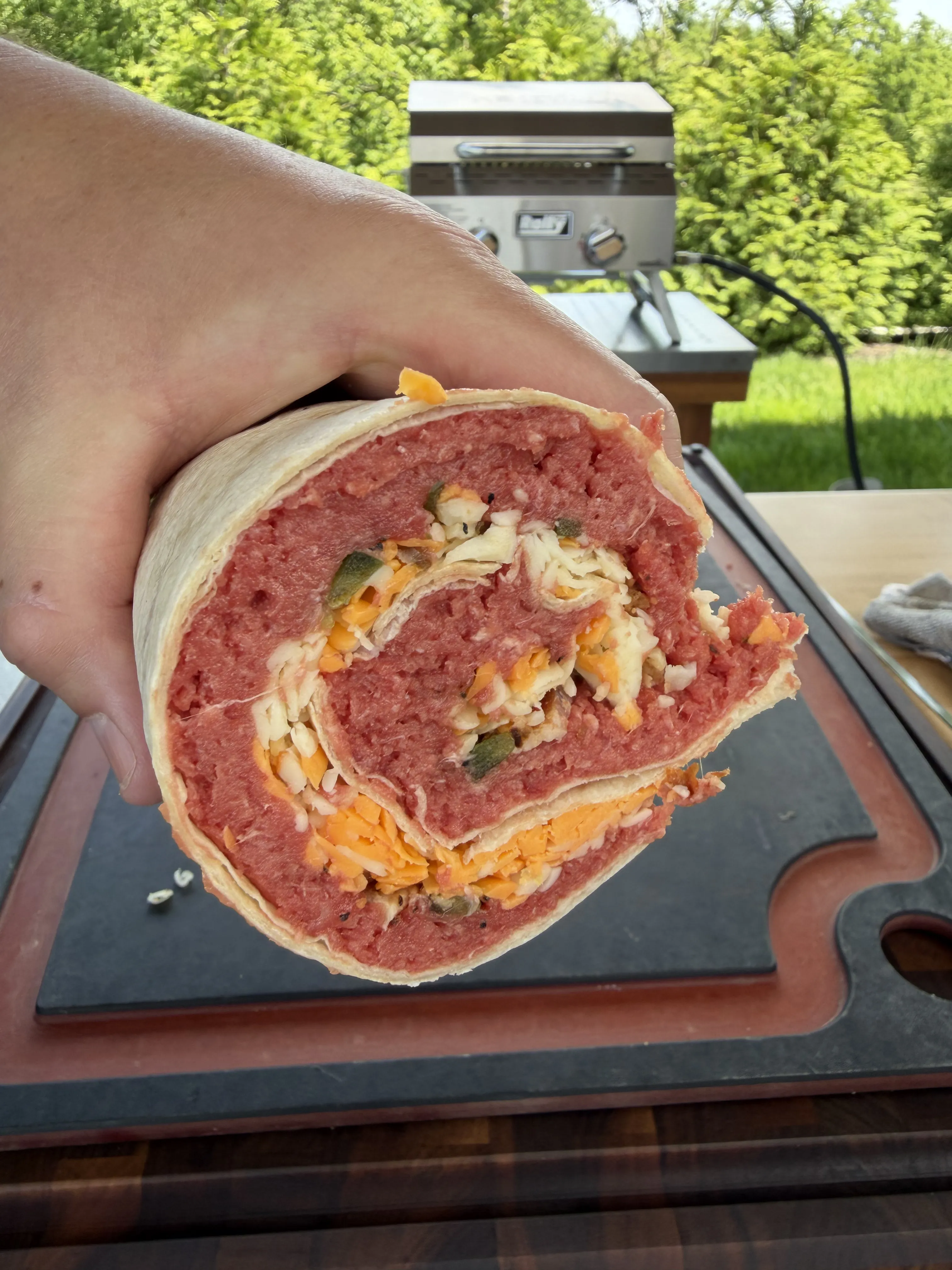 Cross-section of a sliced beef pinwheel tortilla roll showing the spiral layers