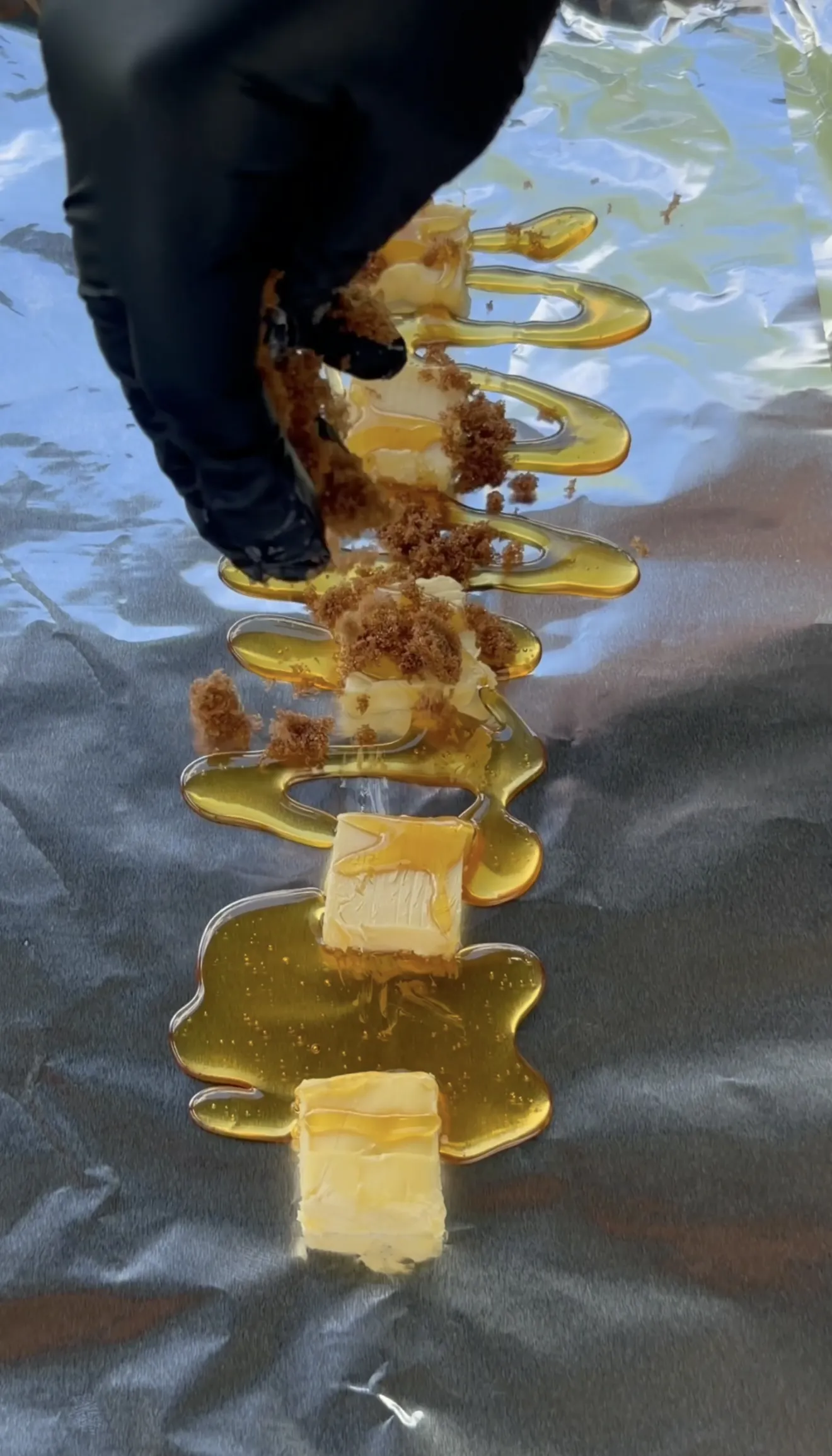 Competition smoked spare ribs being wrapped in foil with honey, brown sugar, and butter