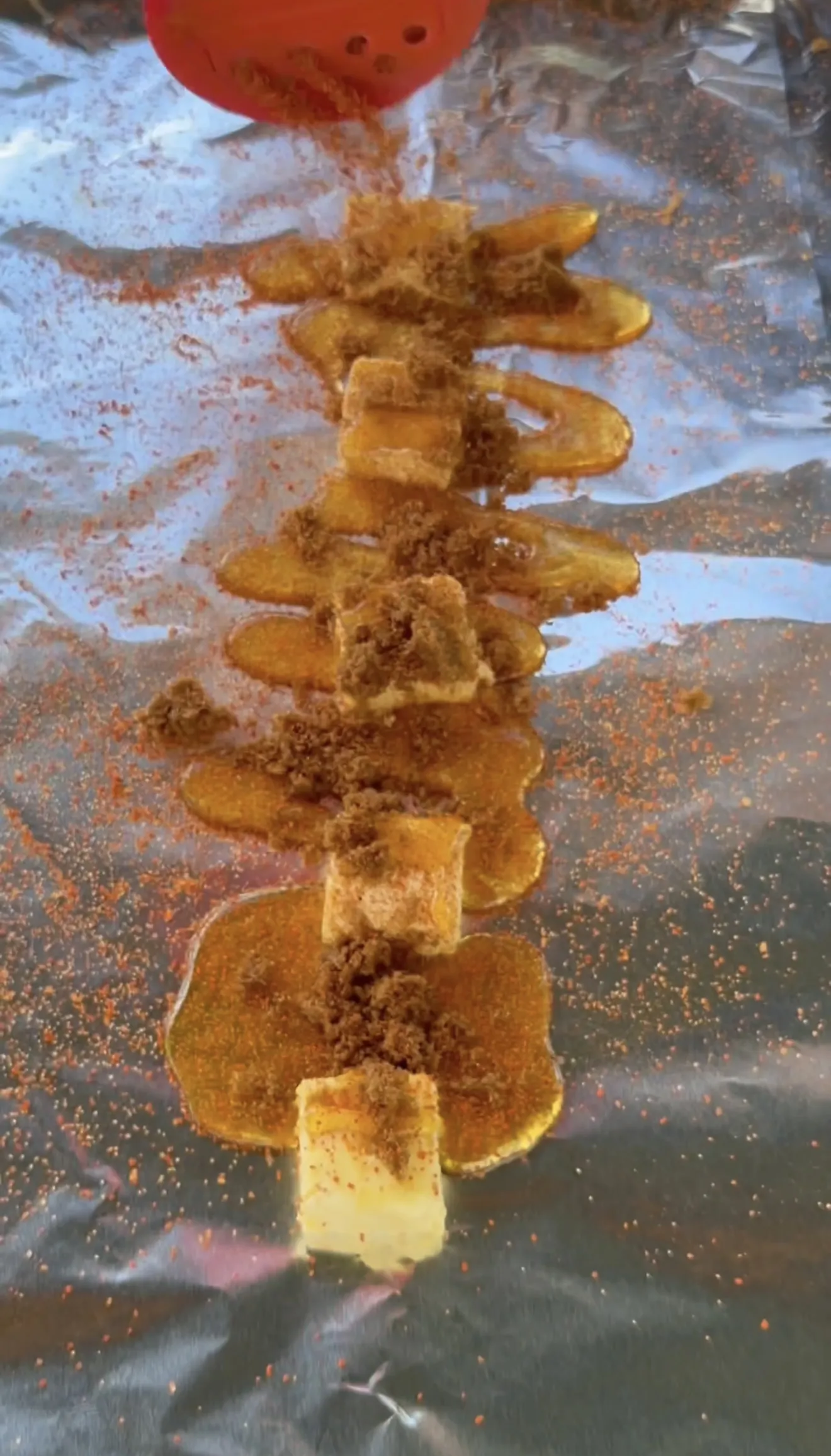 Competition smoked spare ribs on foil topped with brown sugar and honey before wrapping