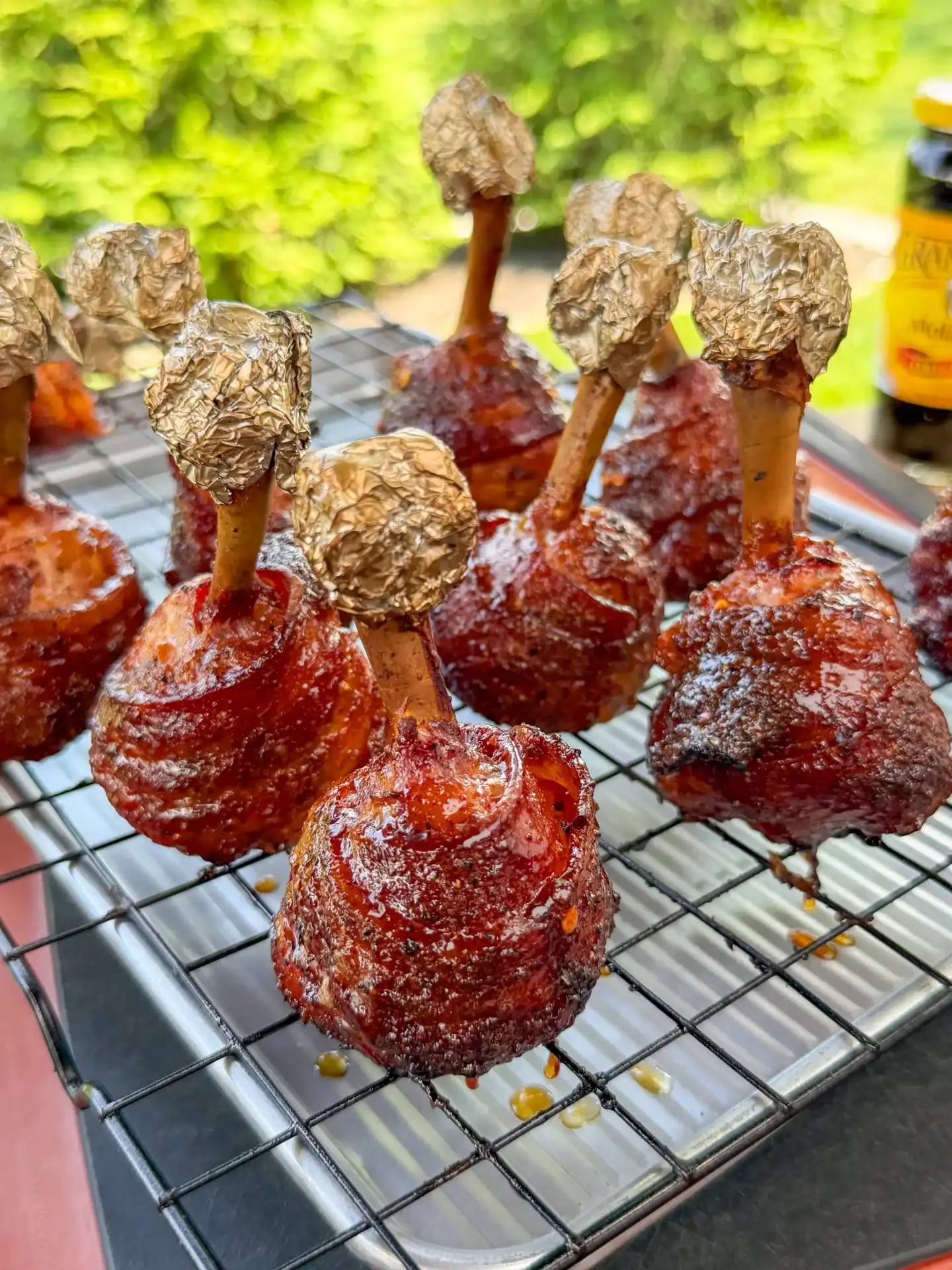 Bacon wrapped chicken lollipops coated with molasses glaze