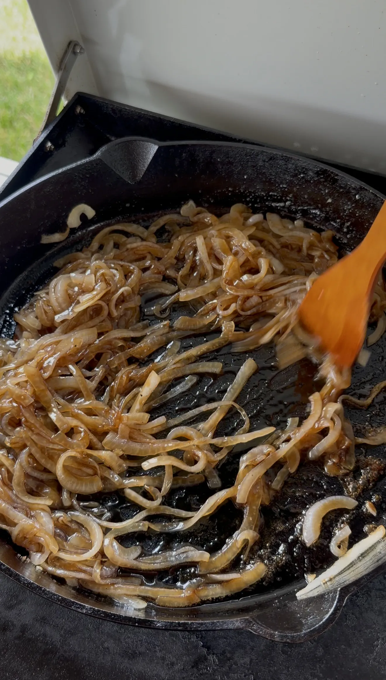 Golden caramelized onions stirred in a cast iron skillet