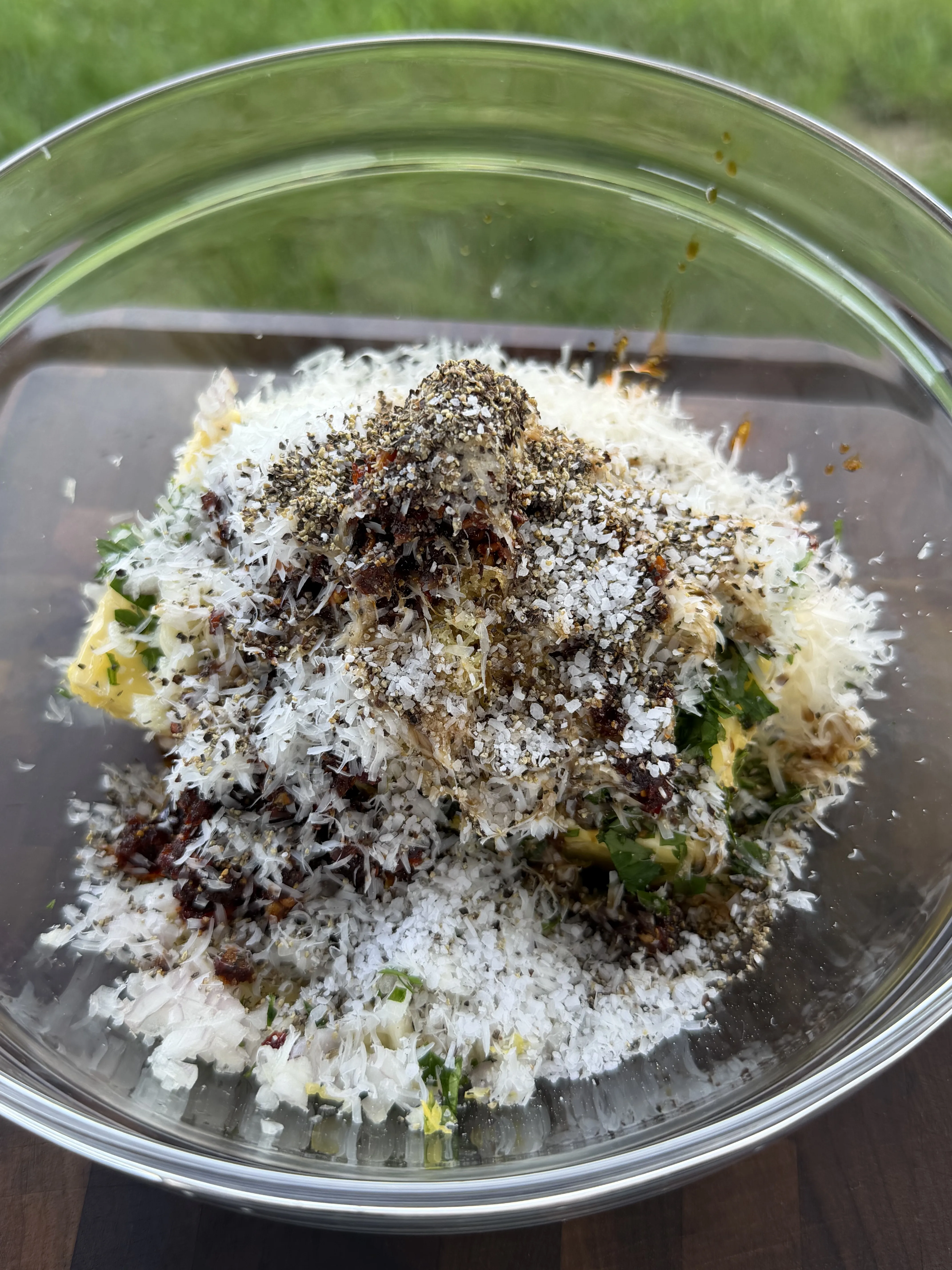 Grated Parmesan, cracked pepper, chili flakes, herbs, and butter ready to mix