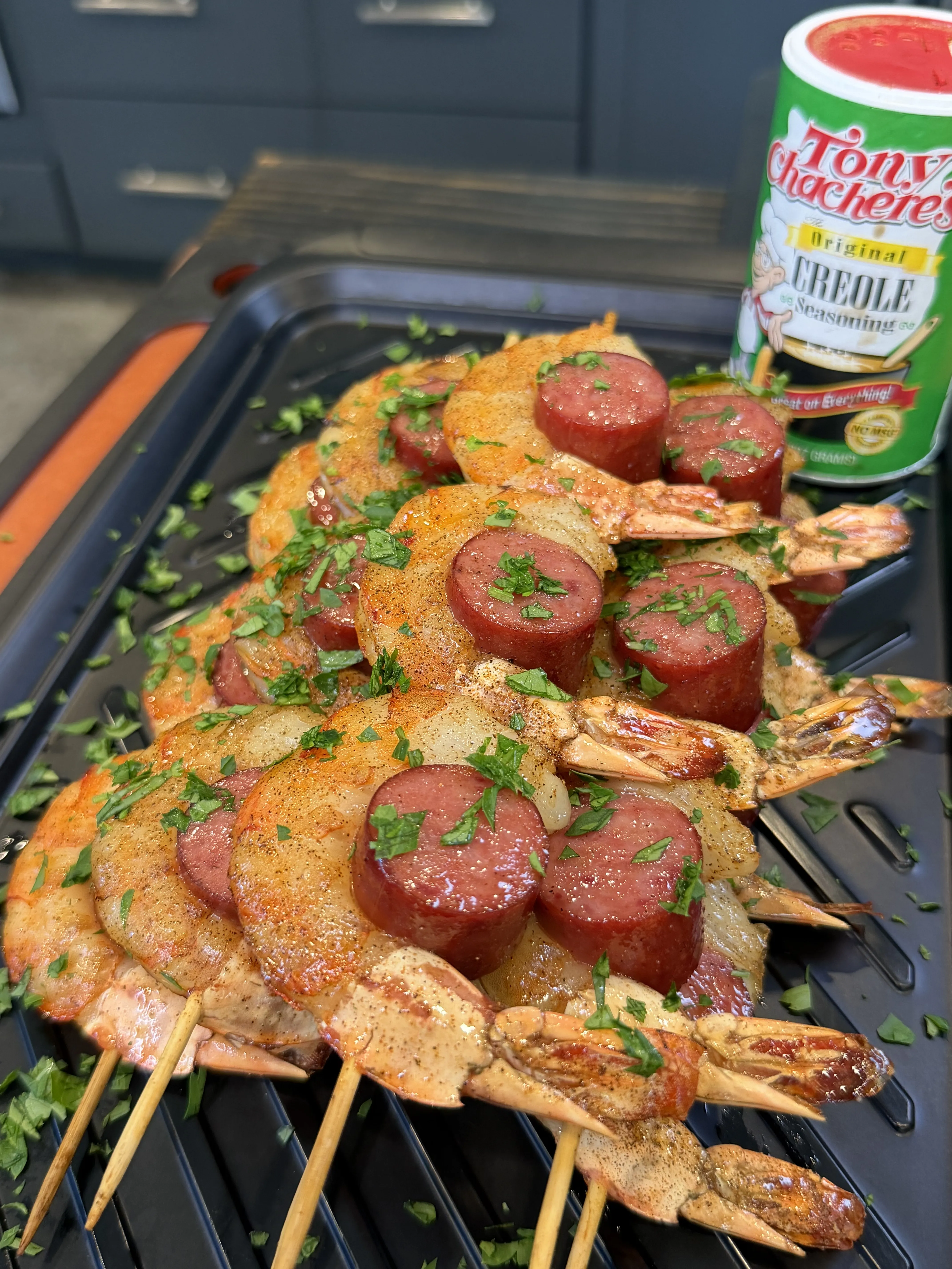 Grilled shrimp and sausage skewers seasoned with Tony Chachere's Creole seasoning, topped with fresh chopped parsley