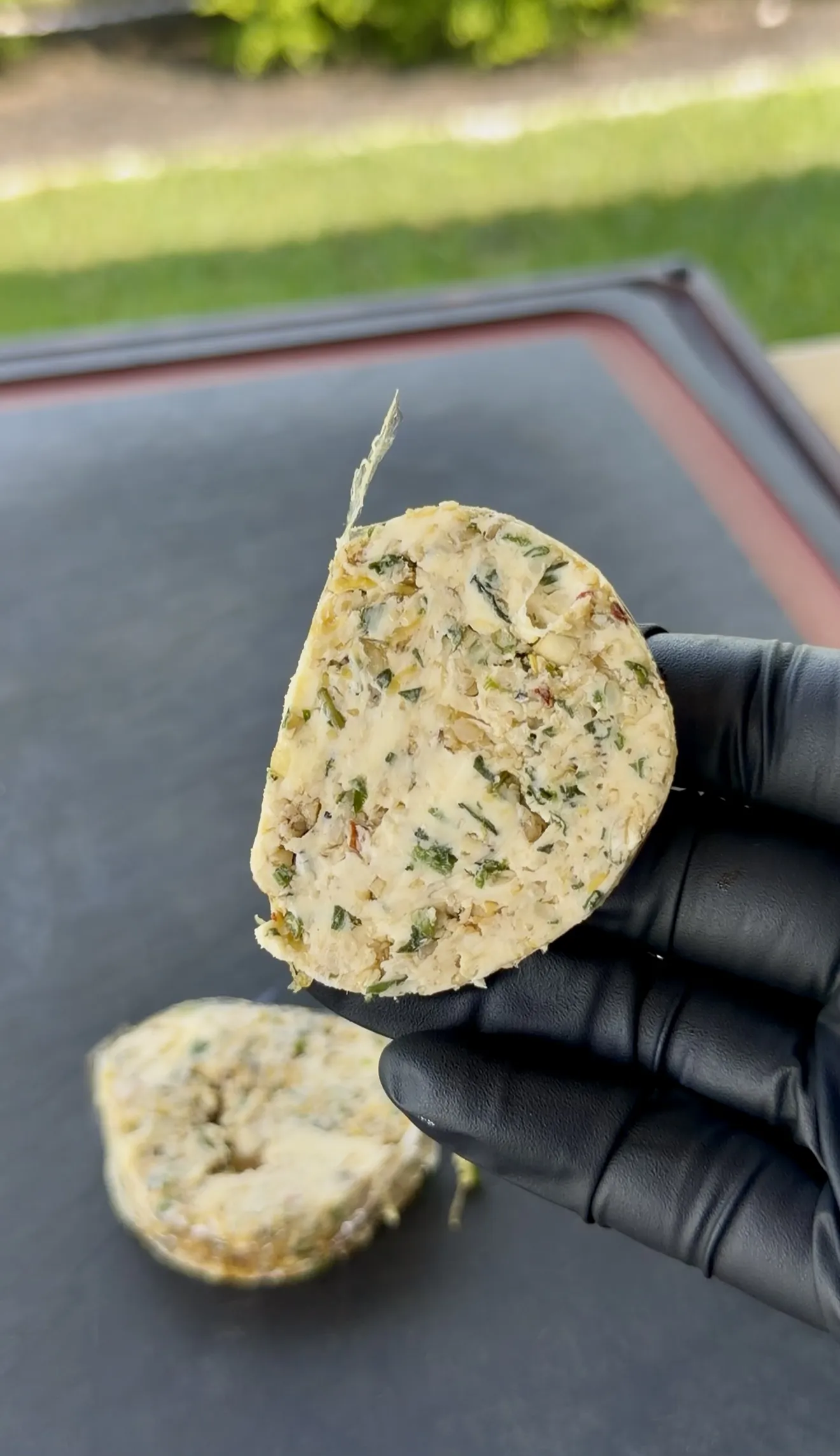 Sliced garlic parmesan basil butter log showing the herb-flecked interior