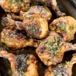 Juicy grilled Cajun chicken drumsticks in a cast iron skillet, garnished with fresh herbs and Weber N'Orleans Cajun seasoning nearby